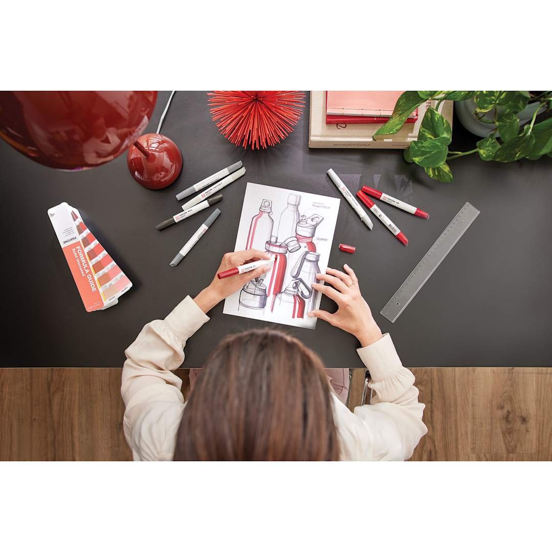 Open in modal - Artist using Pantone Color Guide and Pantone Dual Tip Markers to draw a still life.