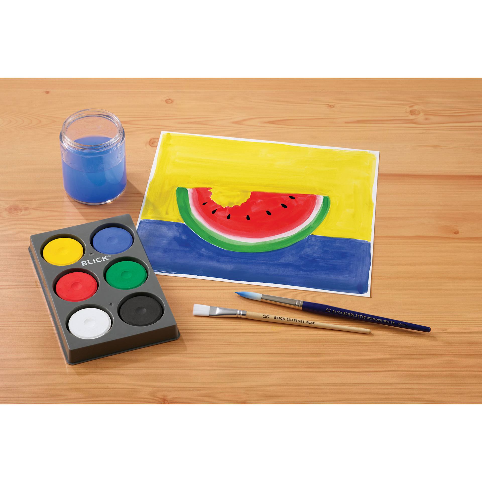 Blick Essentials Tempera Cakes Set of 6 Primary Colors in a Tray with brushes, glass of water, and a painting of a watermelon.