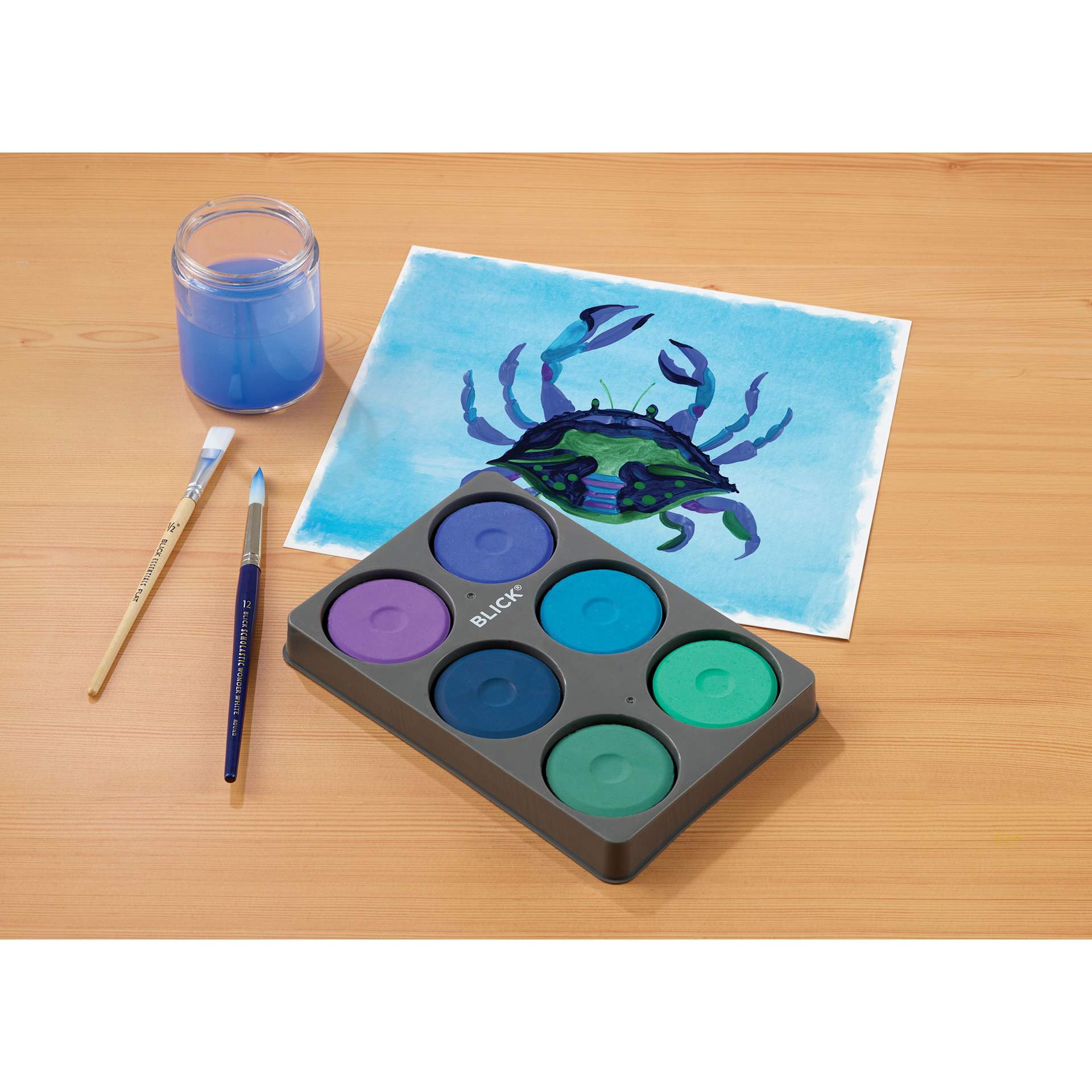 Blick Essentials Tempera Cakes Set of 6 Cool Colors with a Tray, brushes, water cup, and a painting of a crab.