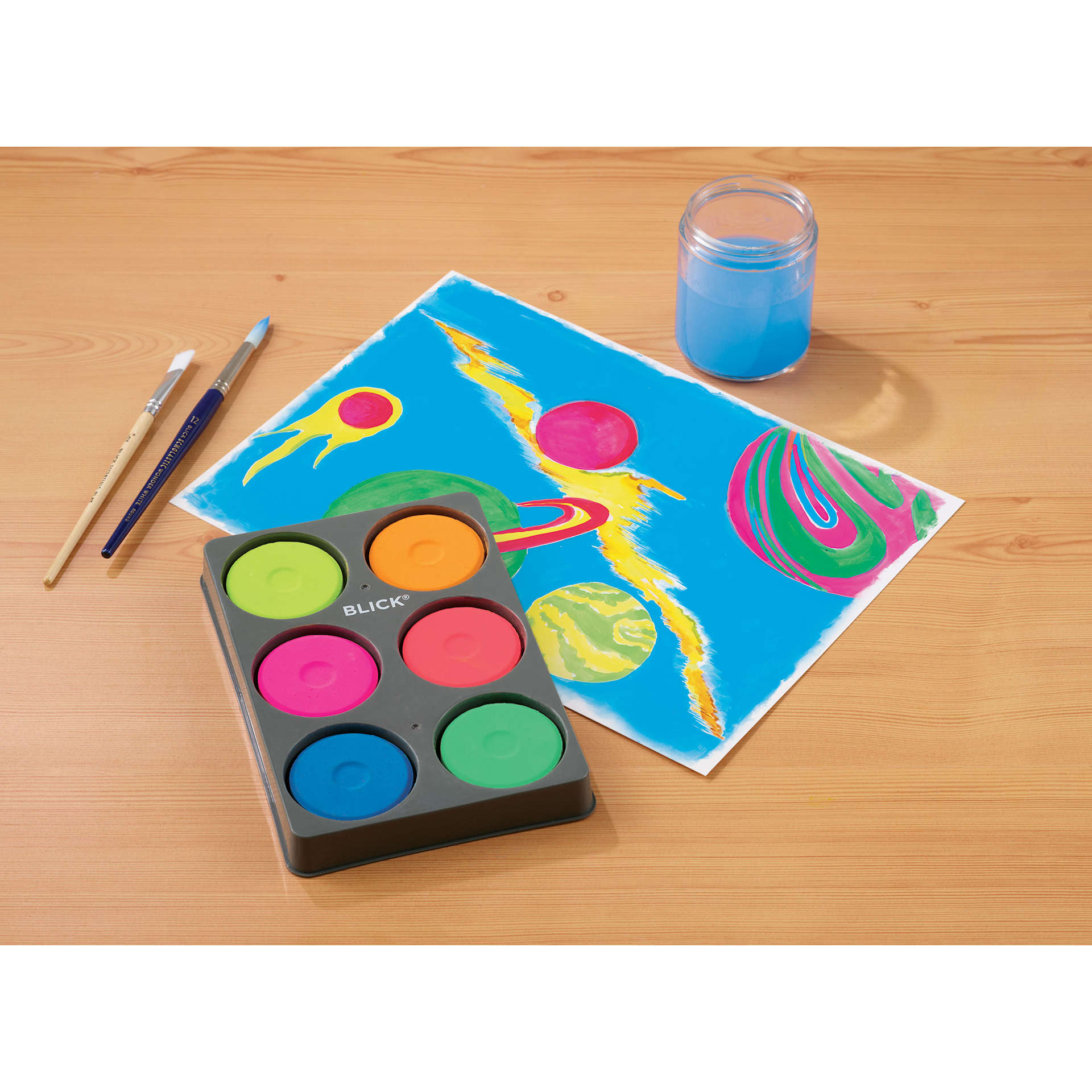 Blick Essentials Tempera Cakes Set of 6 Fluorescent Colors with a Tray, brushes, a cup of water, and an abstract painting.
