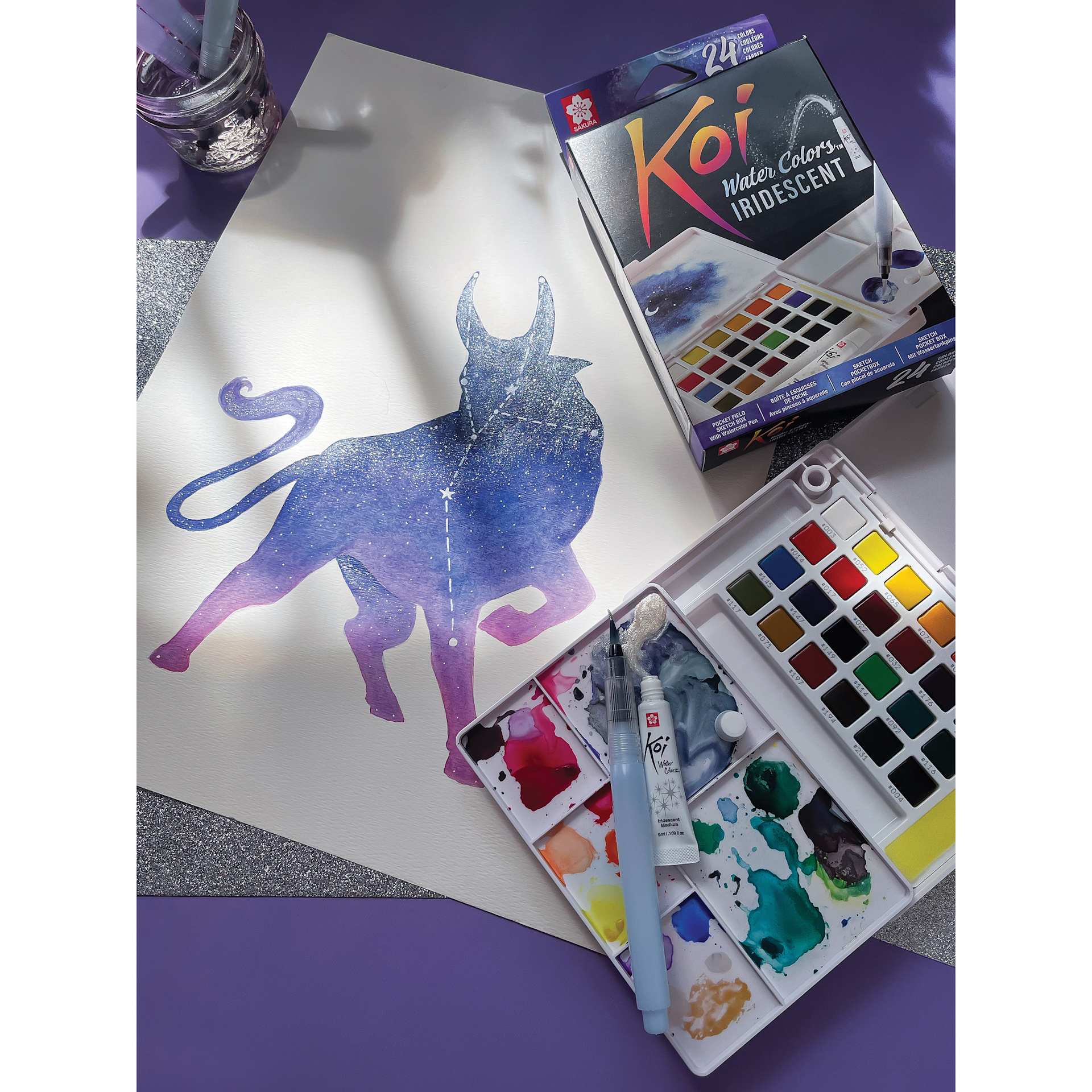 Sakura Koi Watercolor Half Pan - Set of 24 Sketch Box, Assorted Colors with Iridescent Medium box and open set beside painting of constellation