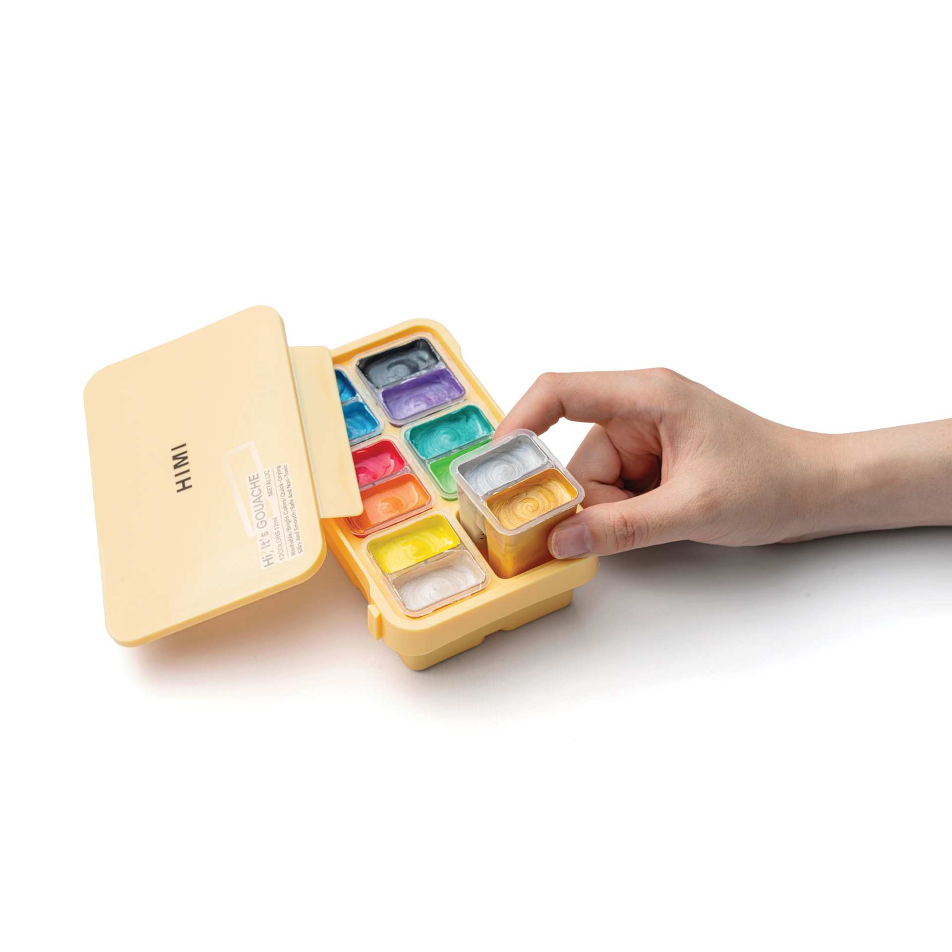 A hand placing a twin cup of paints into the case.