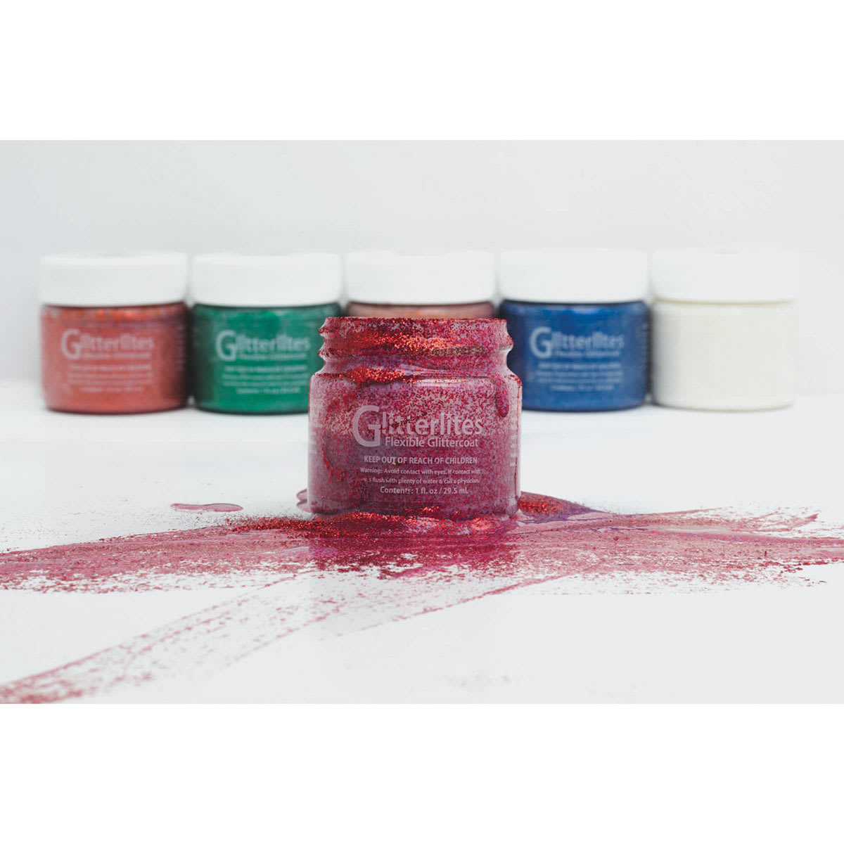 Glitterlites Flexible Glittercoat Paint - Several jars with Candy Pink sitting in pool of paint