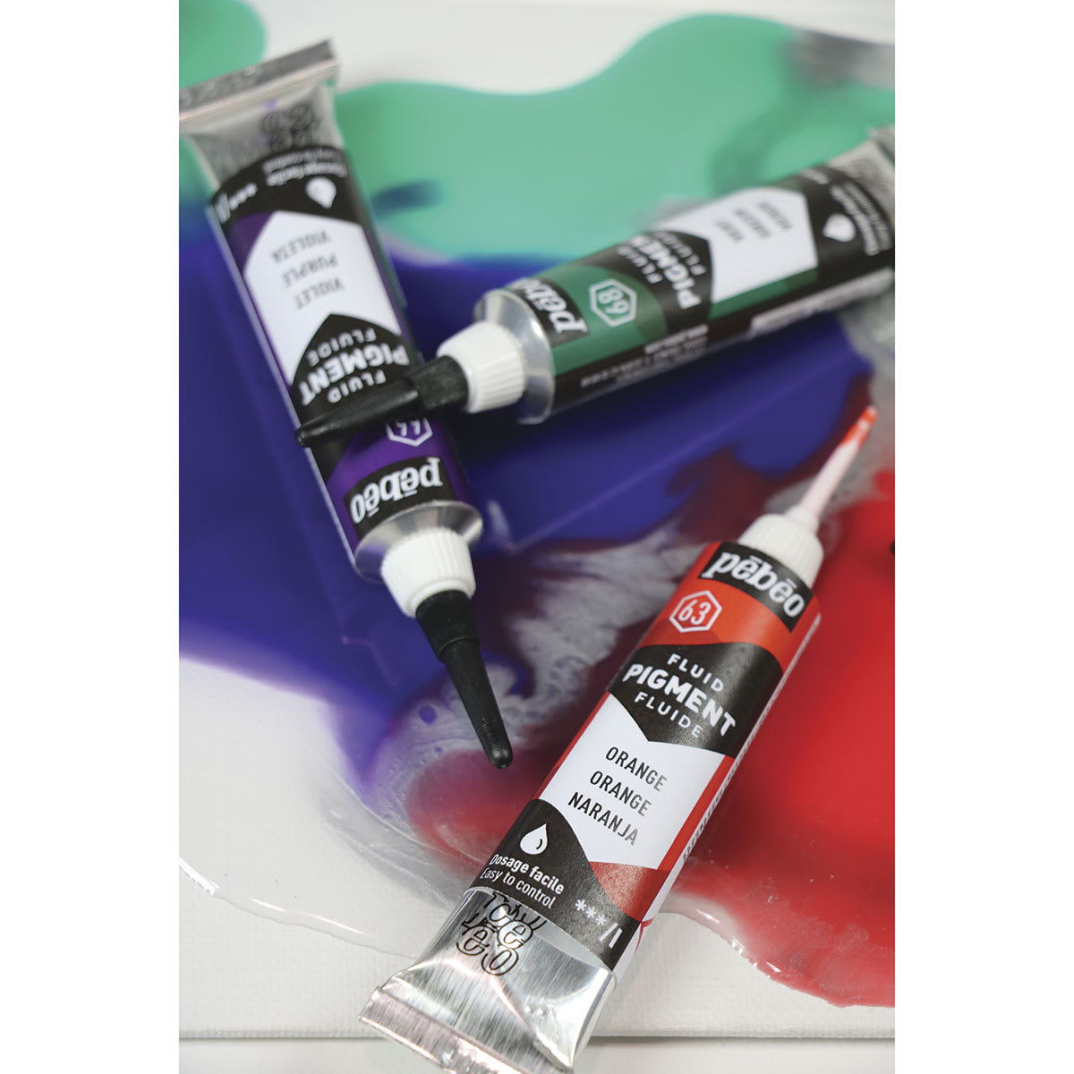Pebeo Fluid Pigments - Green, Violet, and Orange Tubes on artwork