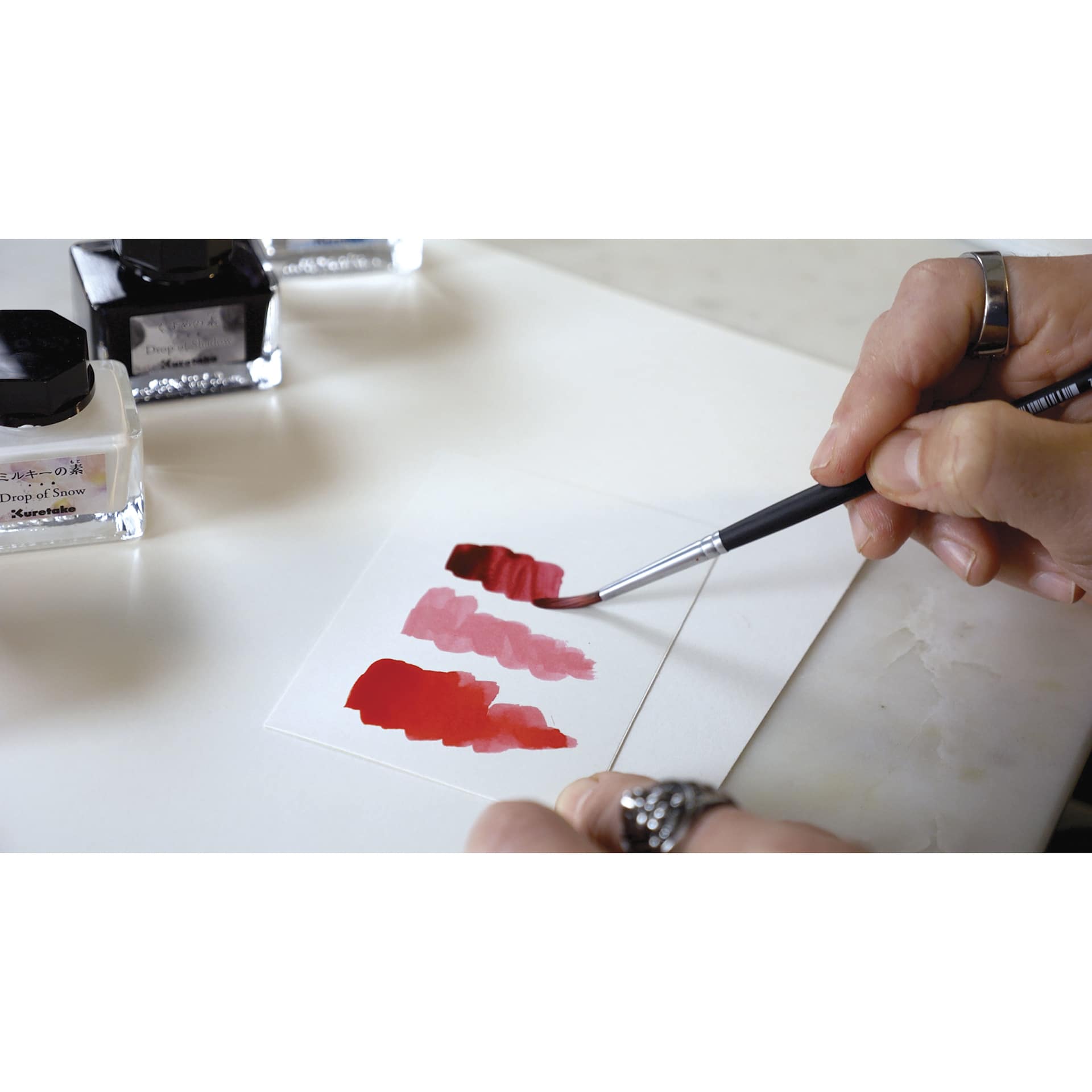 Kuretake Ink-Café Drop of Shadow Ink Additive, brush in hand creating swatch