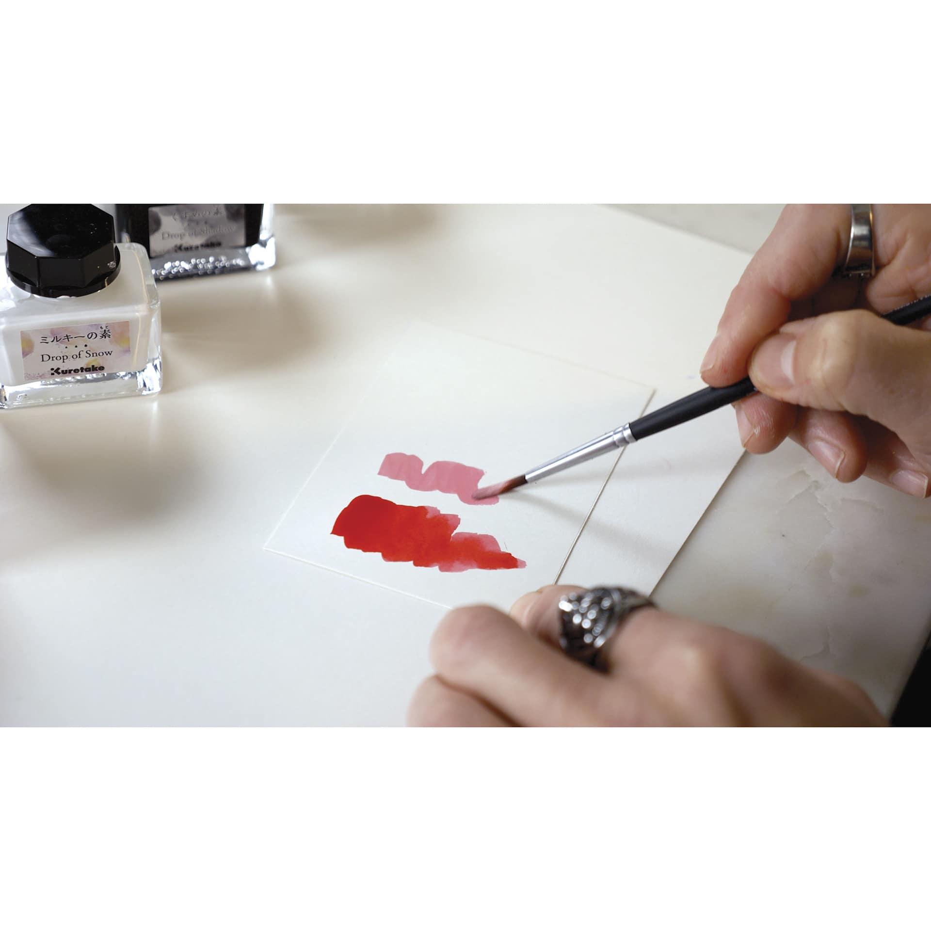 Kuretake Ink-Café Drop of Snow Ink Additive, brush in hand creating a swatch