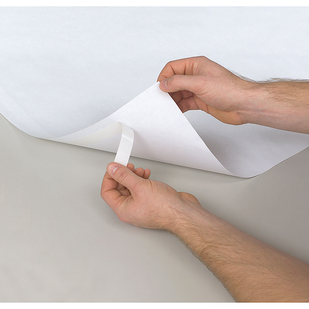 Present-It Easel Pad - Hands removing self-sticking tape from back of sheet
