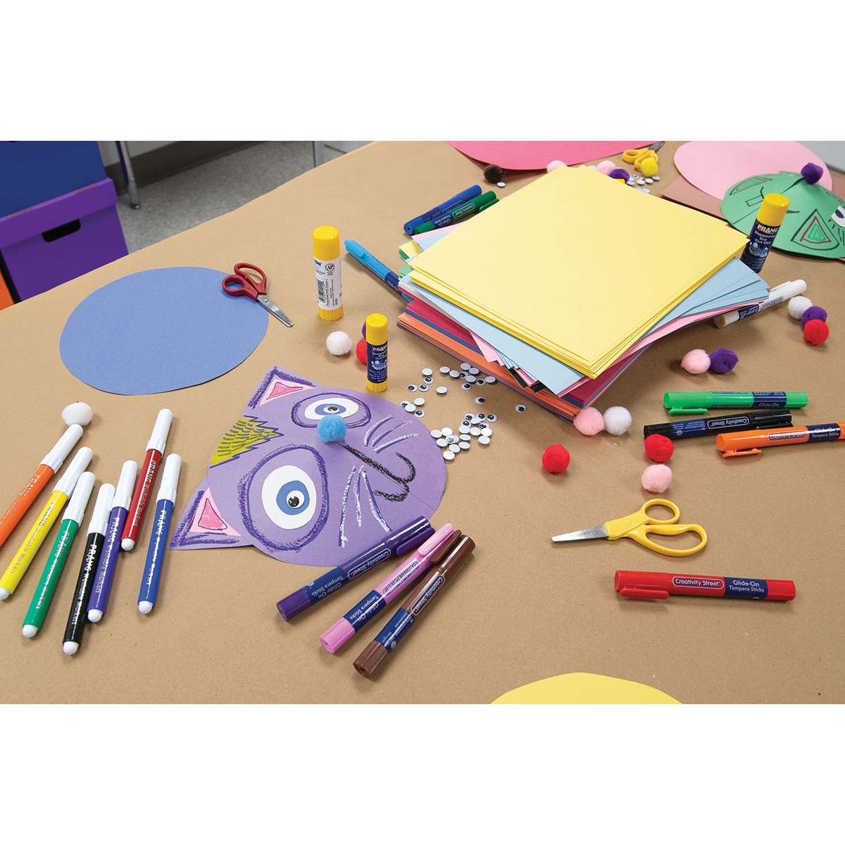 Prang Medium Weight Construction Paper (in use shot of paper on a table with art supplies)