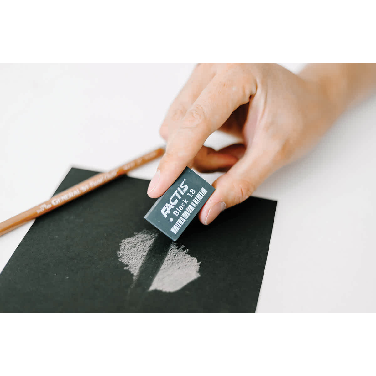 General's Factis Magic Black Eraser -Hand using eraser to remove white shading from black paper