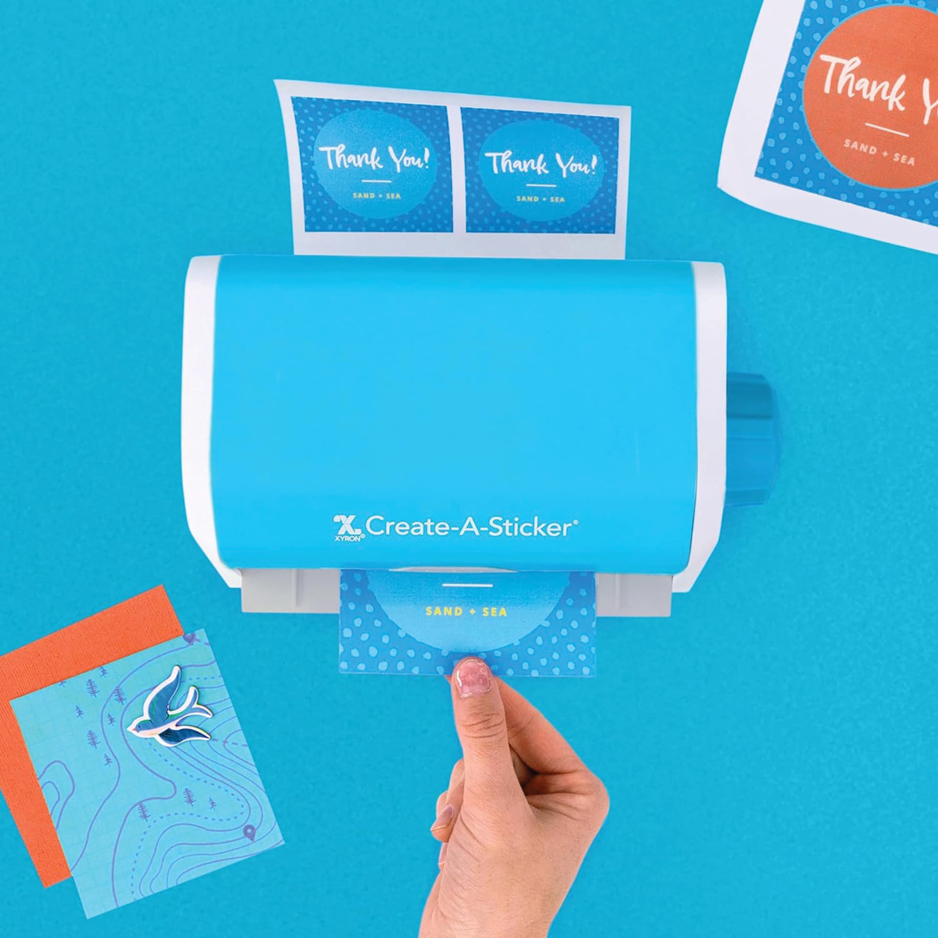 Xyron Create-A-Sticker Sticker Maker, sticker coming out of machine