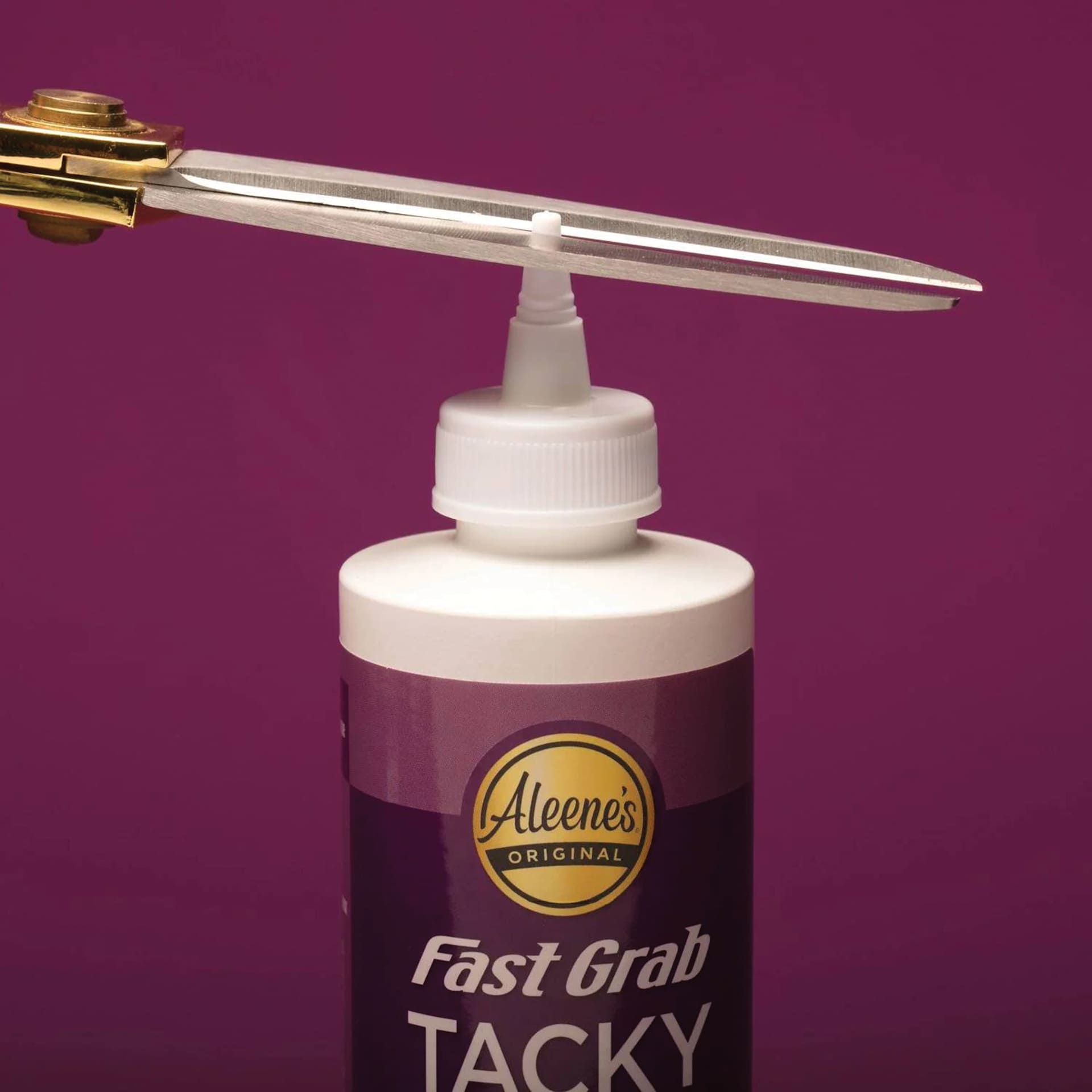 Aleene's Fast Grab Tacky Glue - 8 oz showing glue tip being trimmed off