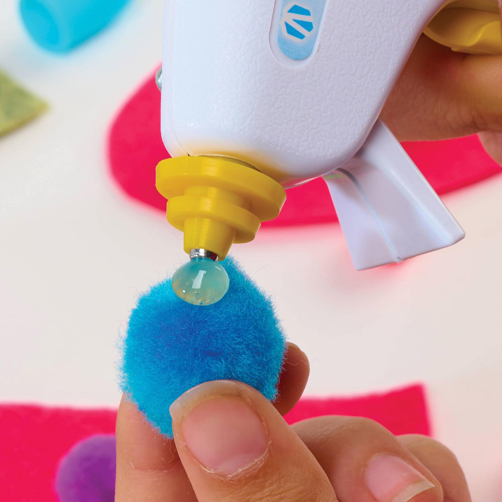 AdTech Cool Tool Super Low Temp Mini Glue Gun, close-up of pom pom being glued