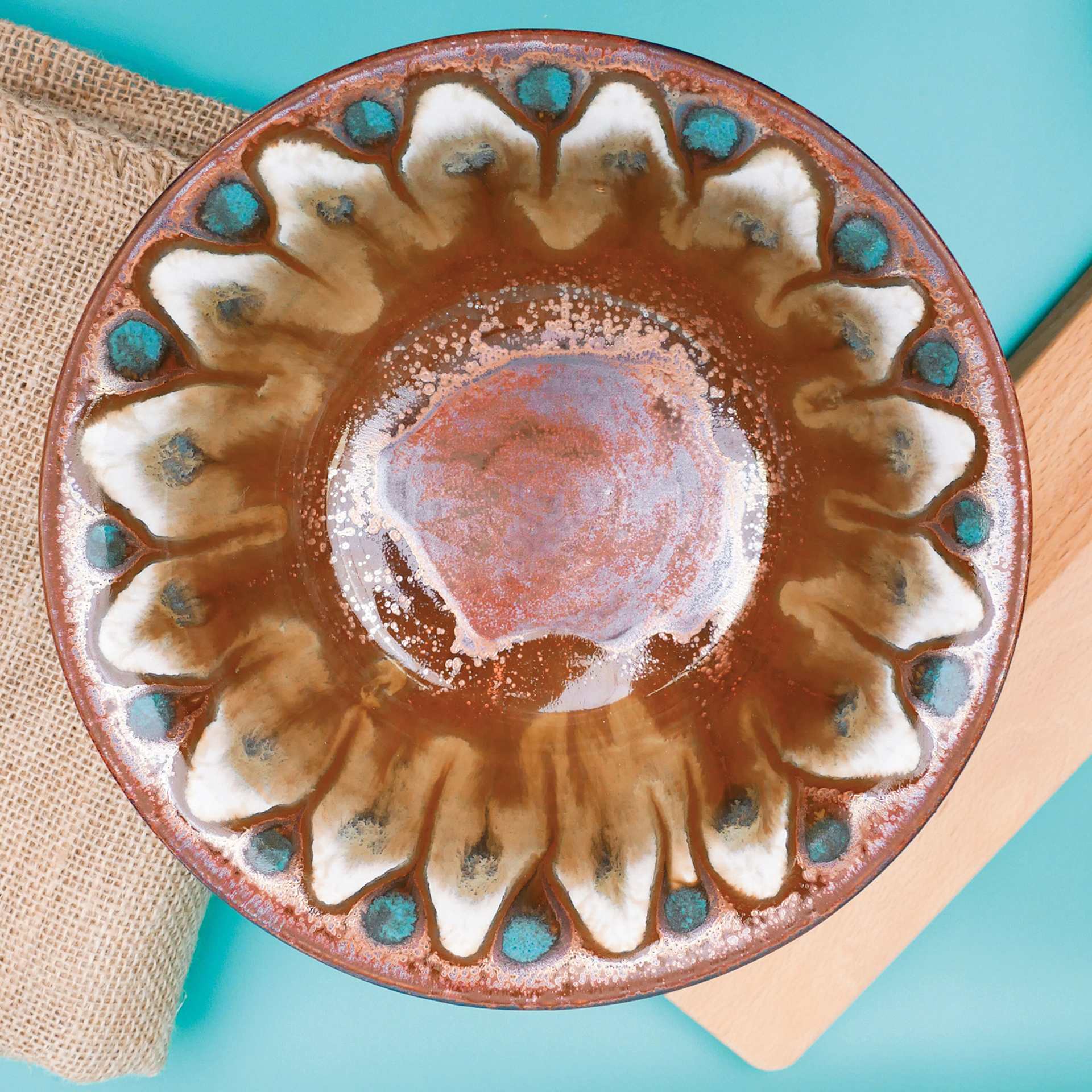 Amaco Potter's Choice Glaze - Ancient Copper applied to a dish in a flower pattern.