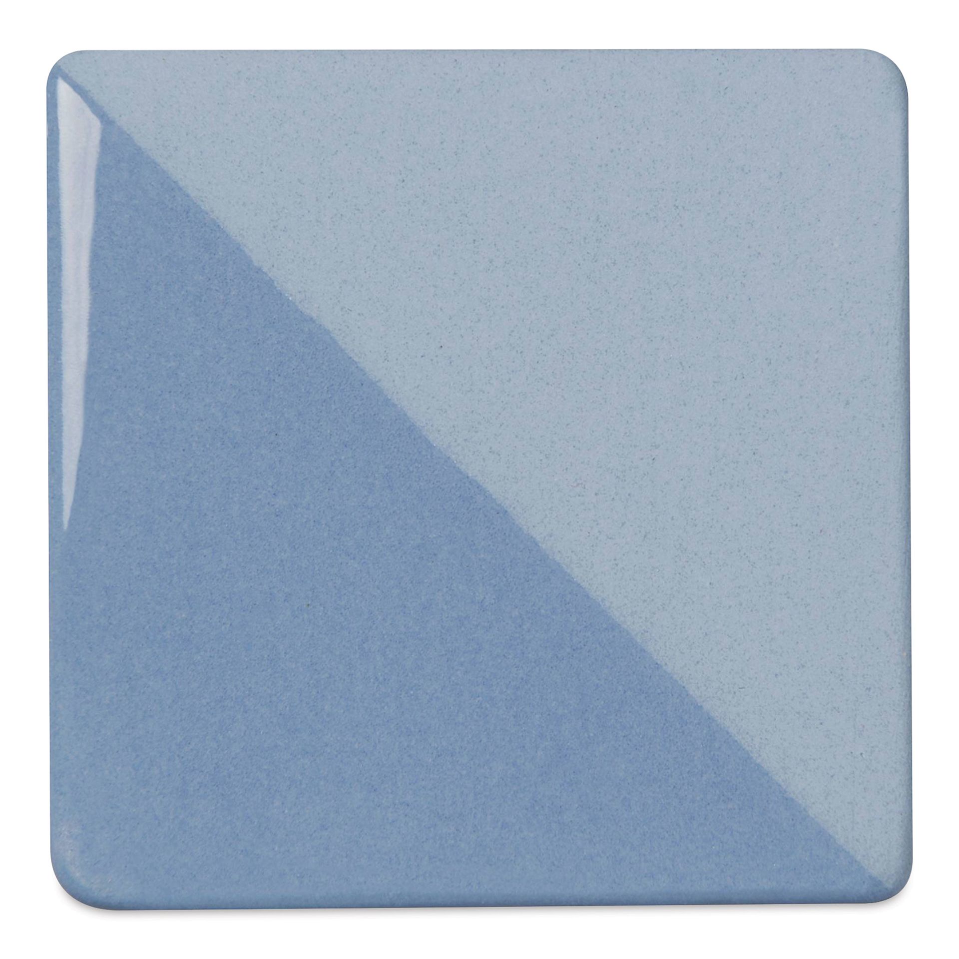 Speedball Ceramic Underglaze - Sky Blue, Opaque, fired on white clay bisque tiles, half covered in Speedball Clear Glaze, fired to cone 05
