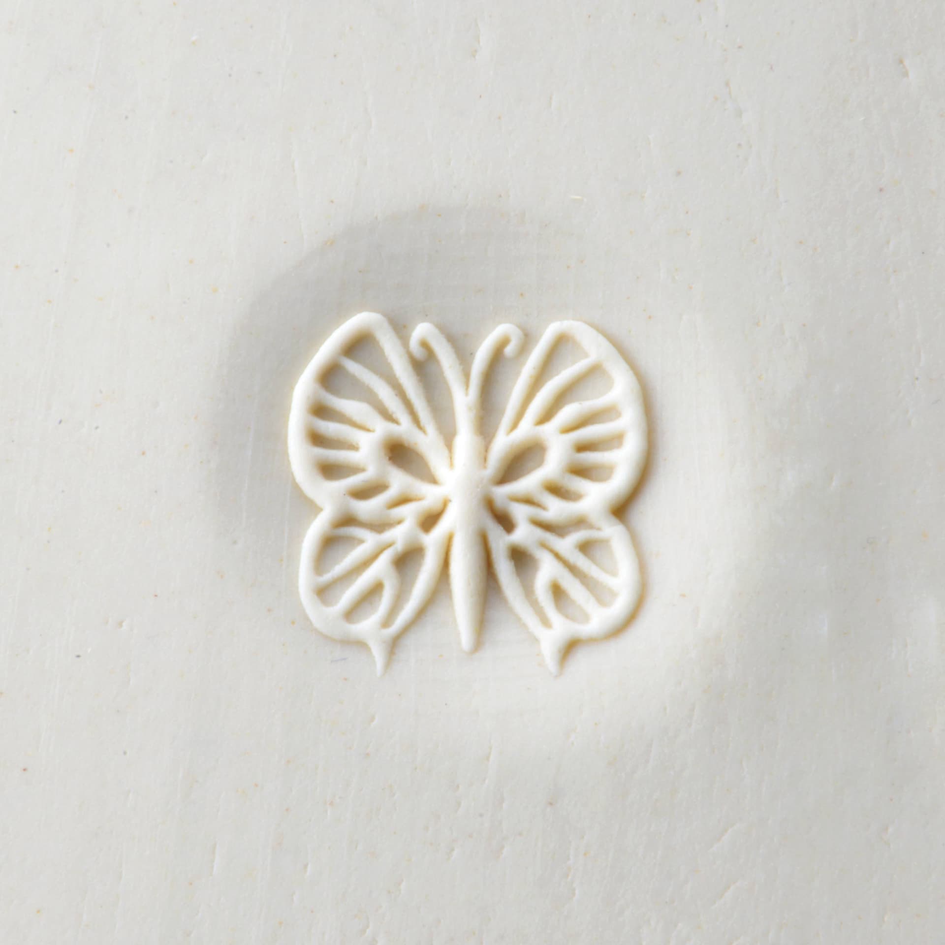 MKM Pottery Tools Curve Top Stamp - Butterfly, stamped into clay