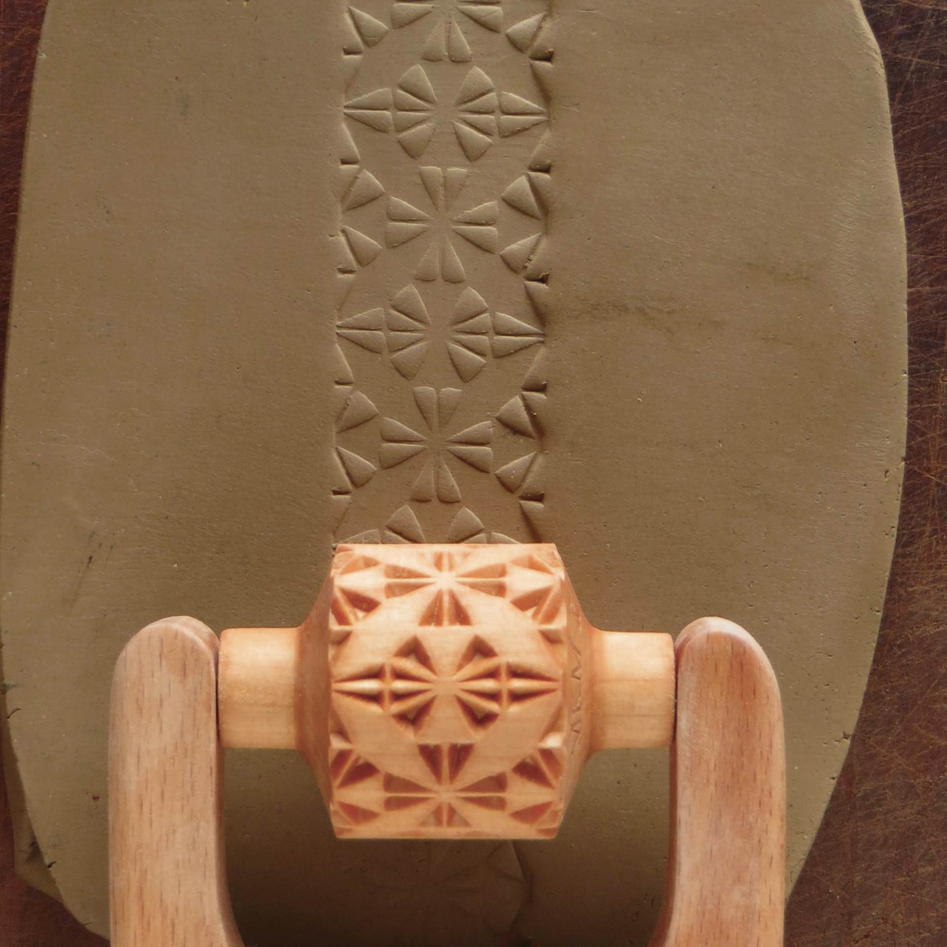 MKM Pottery Tools Medium Handle Roller - 4 Leaf Quilt Block being applied to clay