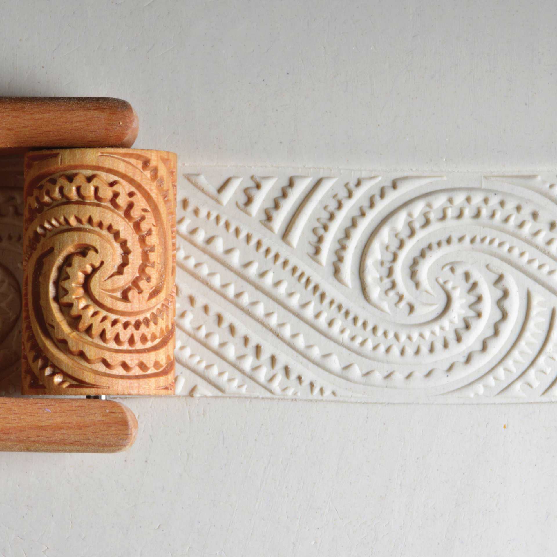 MKM Pottery Tools Large Handle Roller - Maori Spirals 2 applied to clay