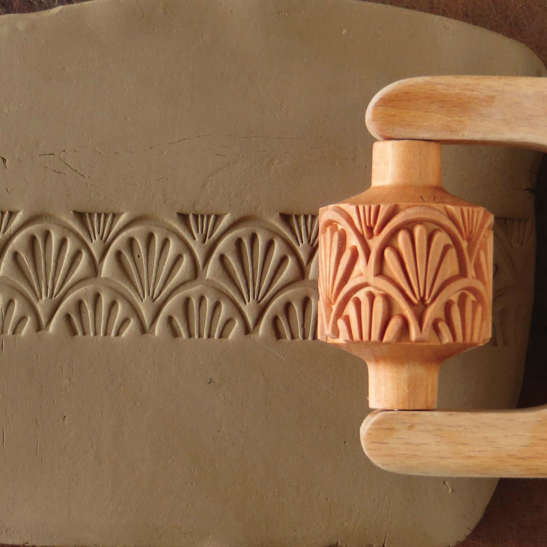 MKM Pottery Tools Medium Handle Roller - Art Nouveau being applied to clay