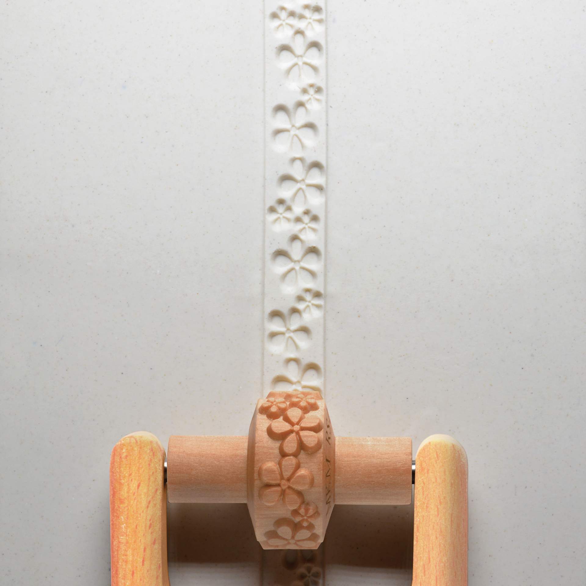 MKM Pottery Tools Small Handle Roller - Embossed Flowers applied to clay