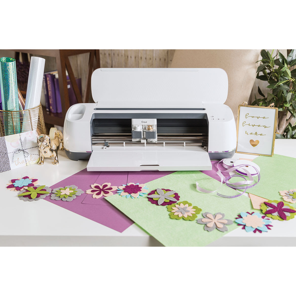 Cricut Maker shown with vinyl and finished items