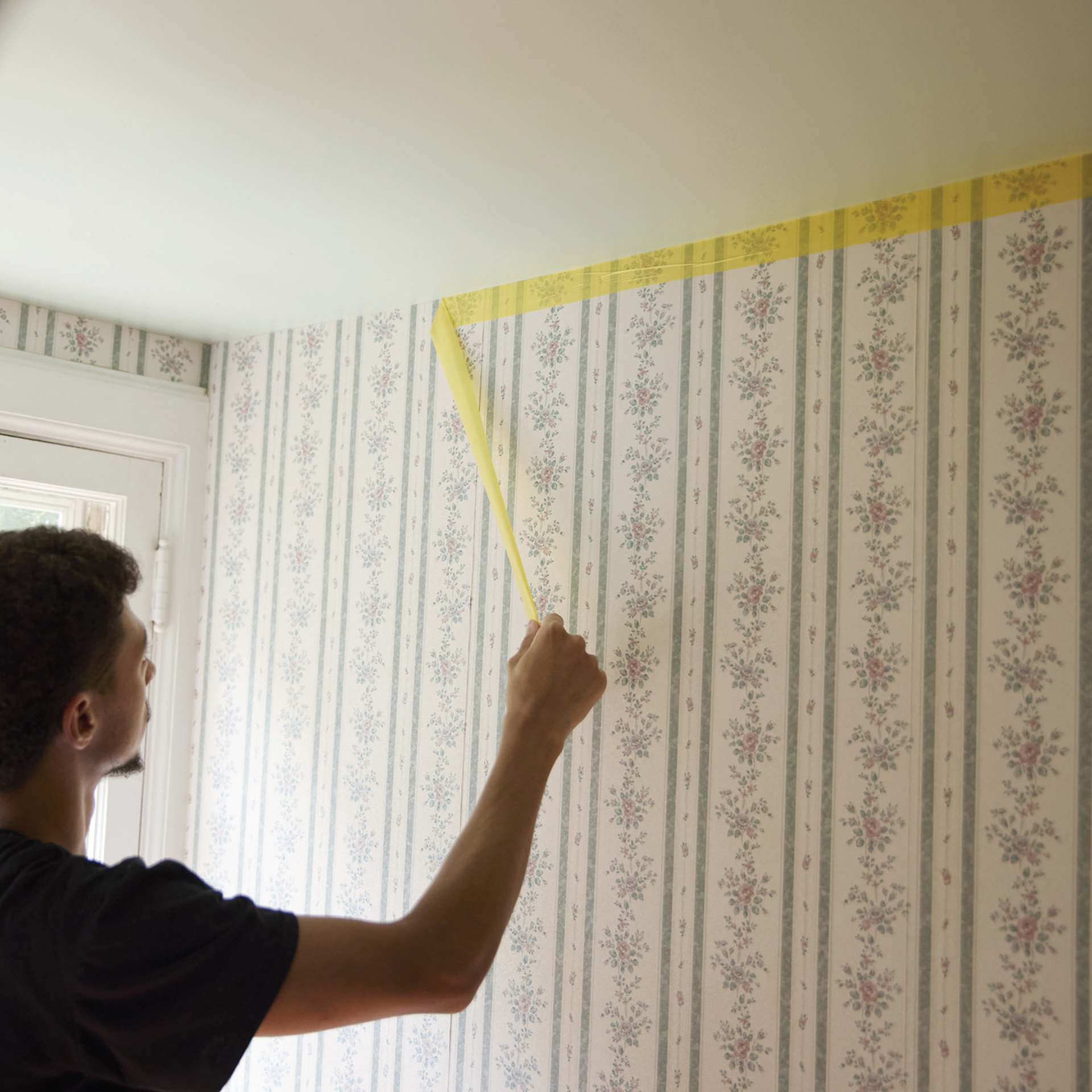 FrogTape Delicate Surface Painter's Tape being removed from wall
