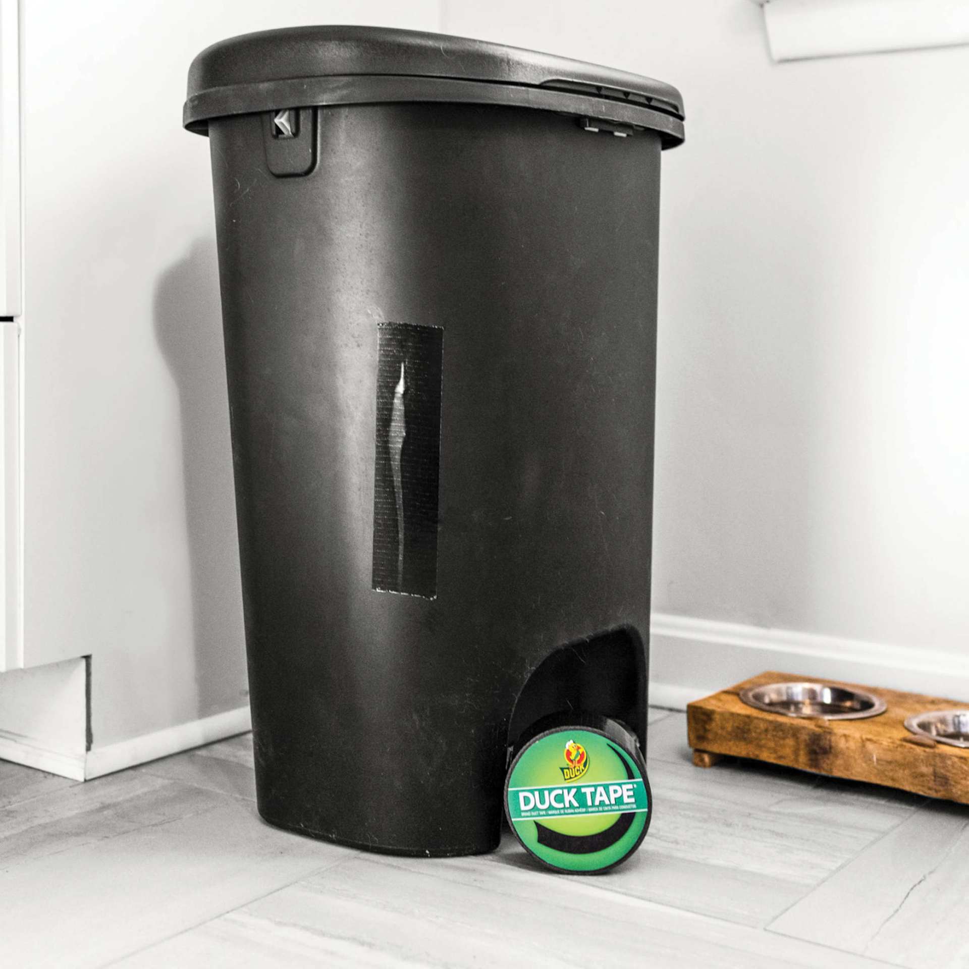 ShurTech Color Duck Tape - 1.88" x 20 yds, Black roll next to taped trashcan