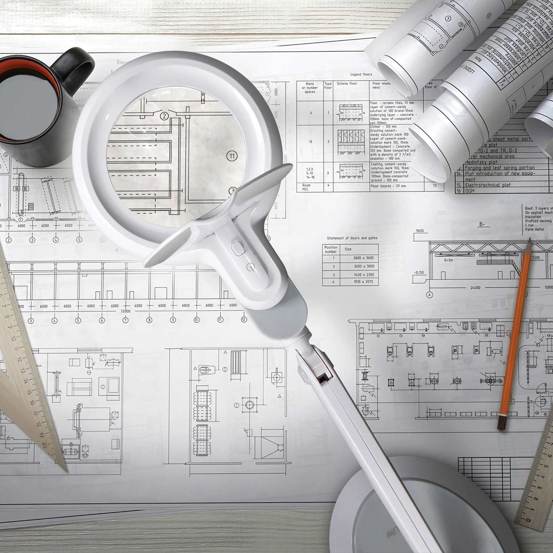 OttLite Space-Saving LED Magnifier Desk Lamp - White, used with design plans on a desk