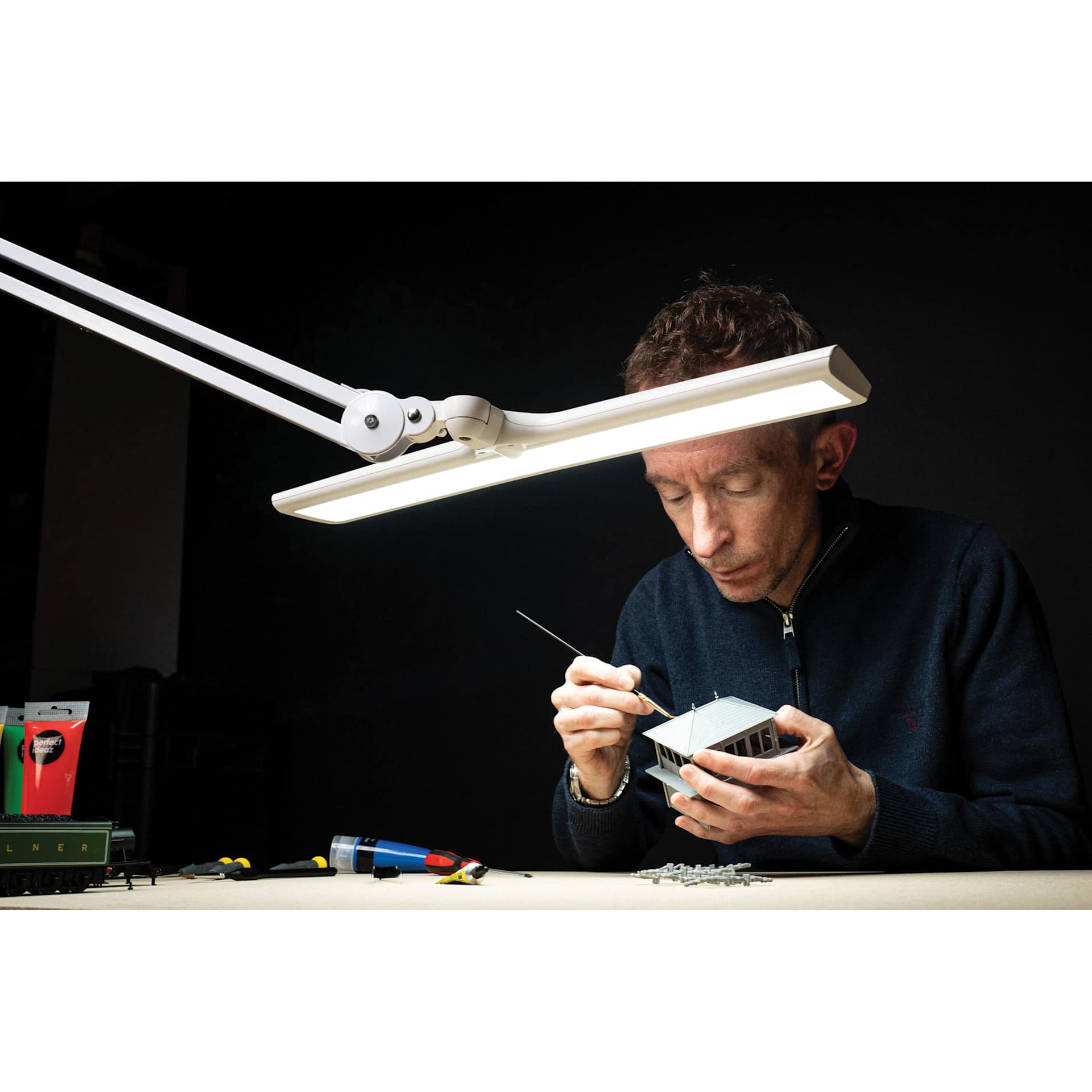 Daylight Lumi Task Lamp - White, in use with model building project