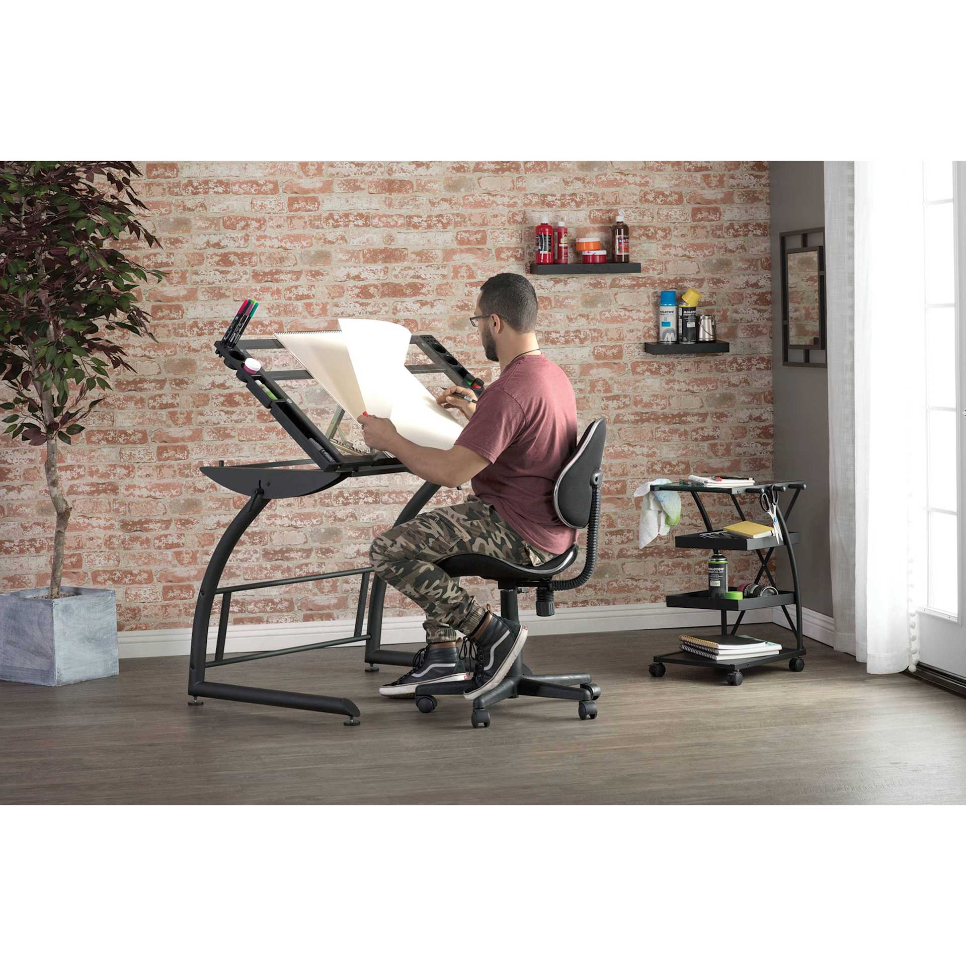 Studio Designs Mode Chair, person seated on chair working on drafting table