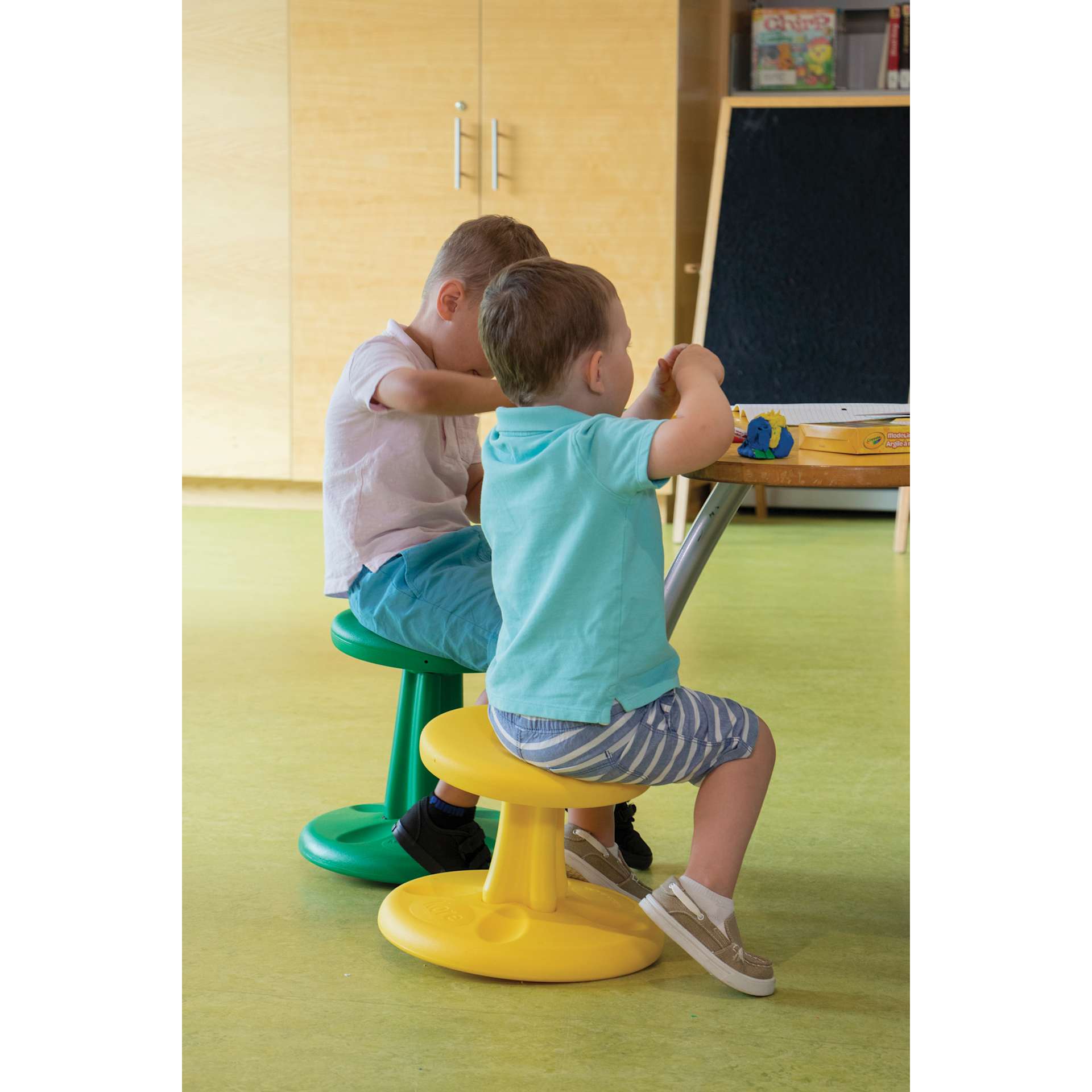 Two children using the Kore Design Kids Wobble Stools at an easel.