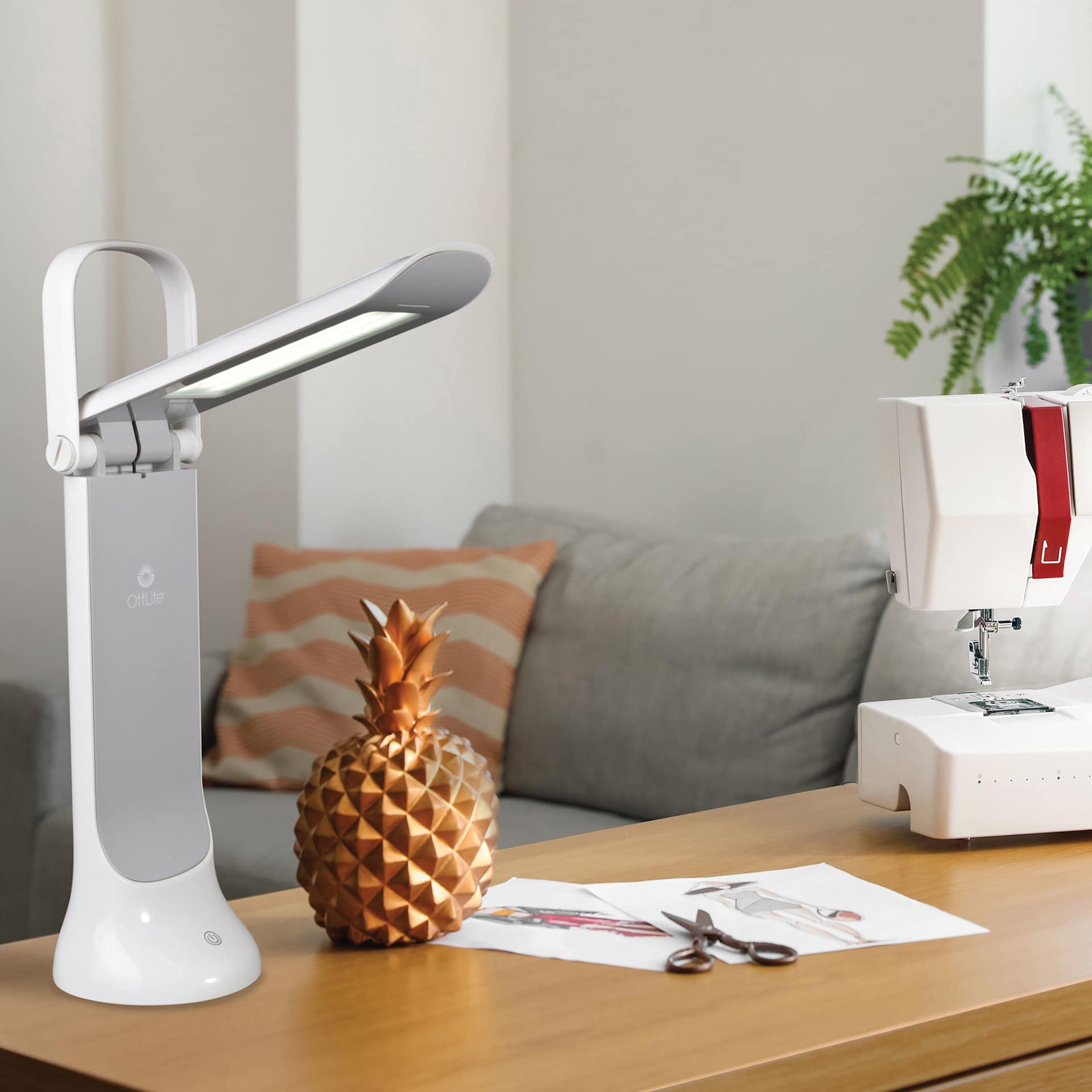 OttLite Dimmable LED Task Lamp - White, on a sewing desk