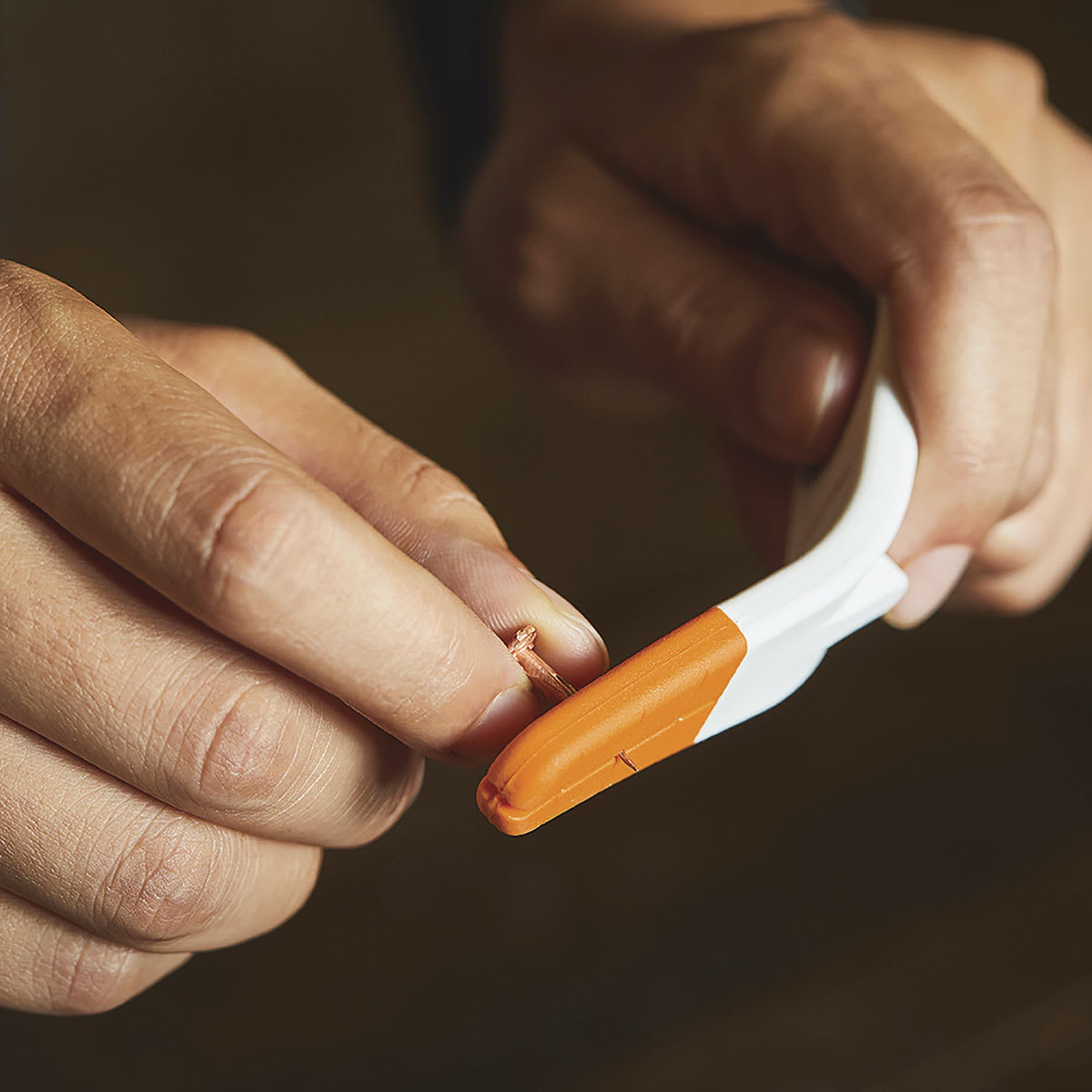 Fiskars Precision Nail Starter - Hand inserting nail in Tool