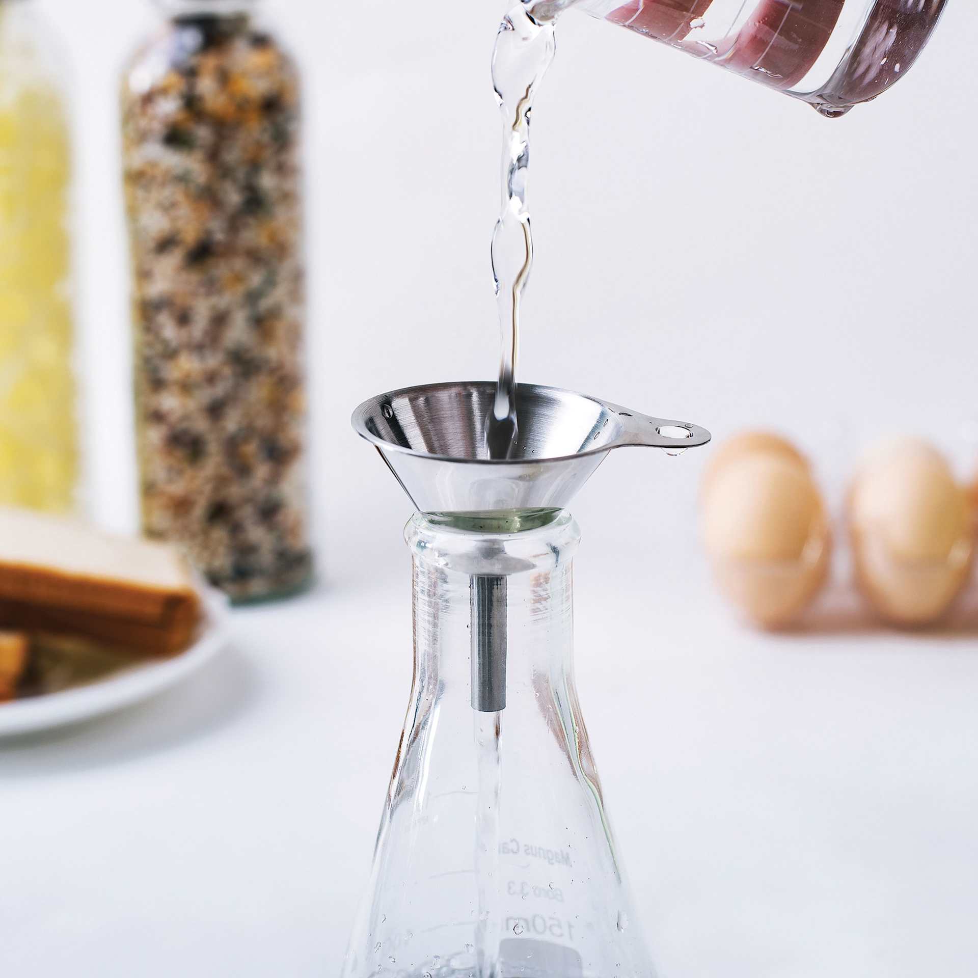Fox Run Stainless Steel Funnel Set - Set of 3 funneling fluid into flask