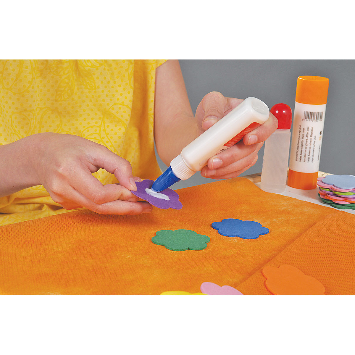 Art and Decoration Fabric - Closeup of fabric flower shapes being glued onto another piece of fabric
