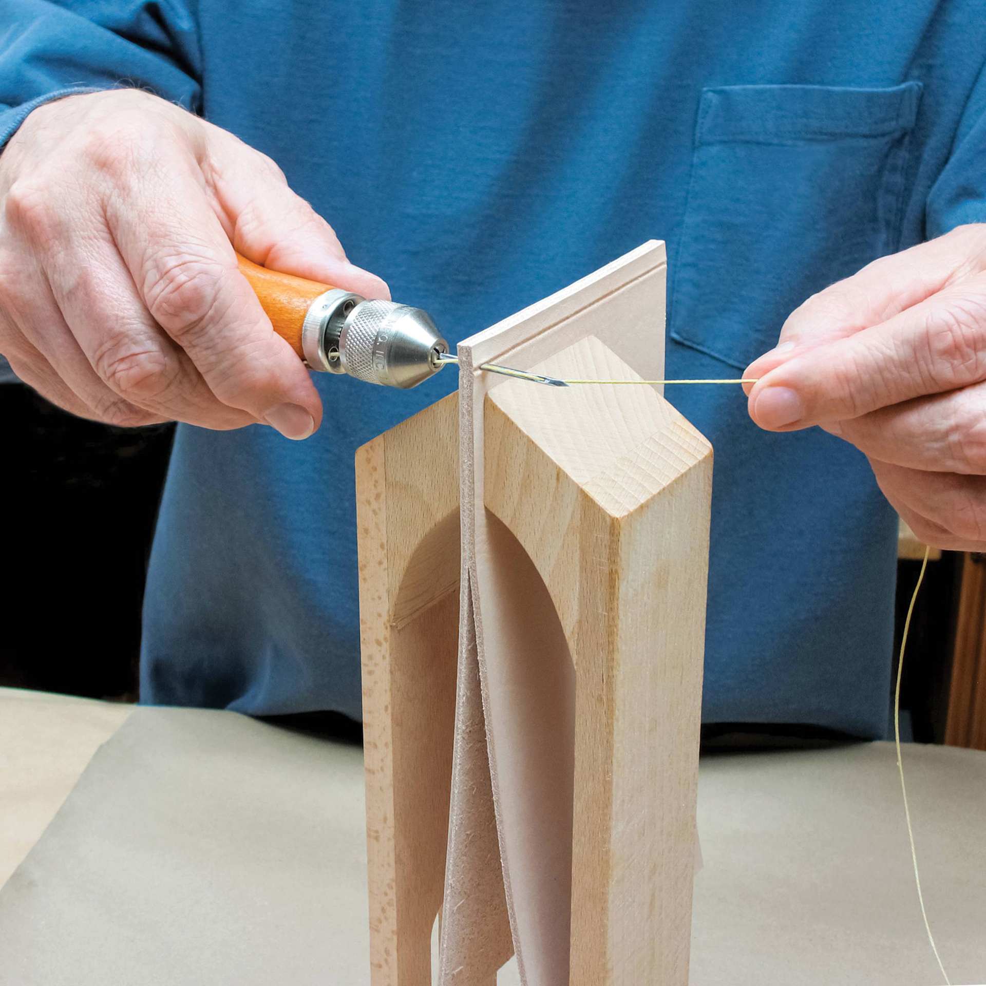Speedy Stitcher Sewing Awl Kit, in use, punching thread through leather