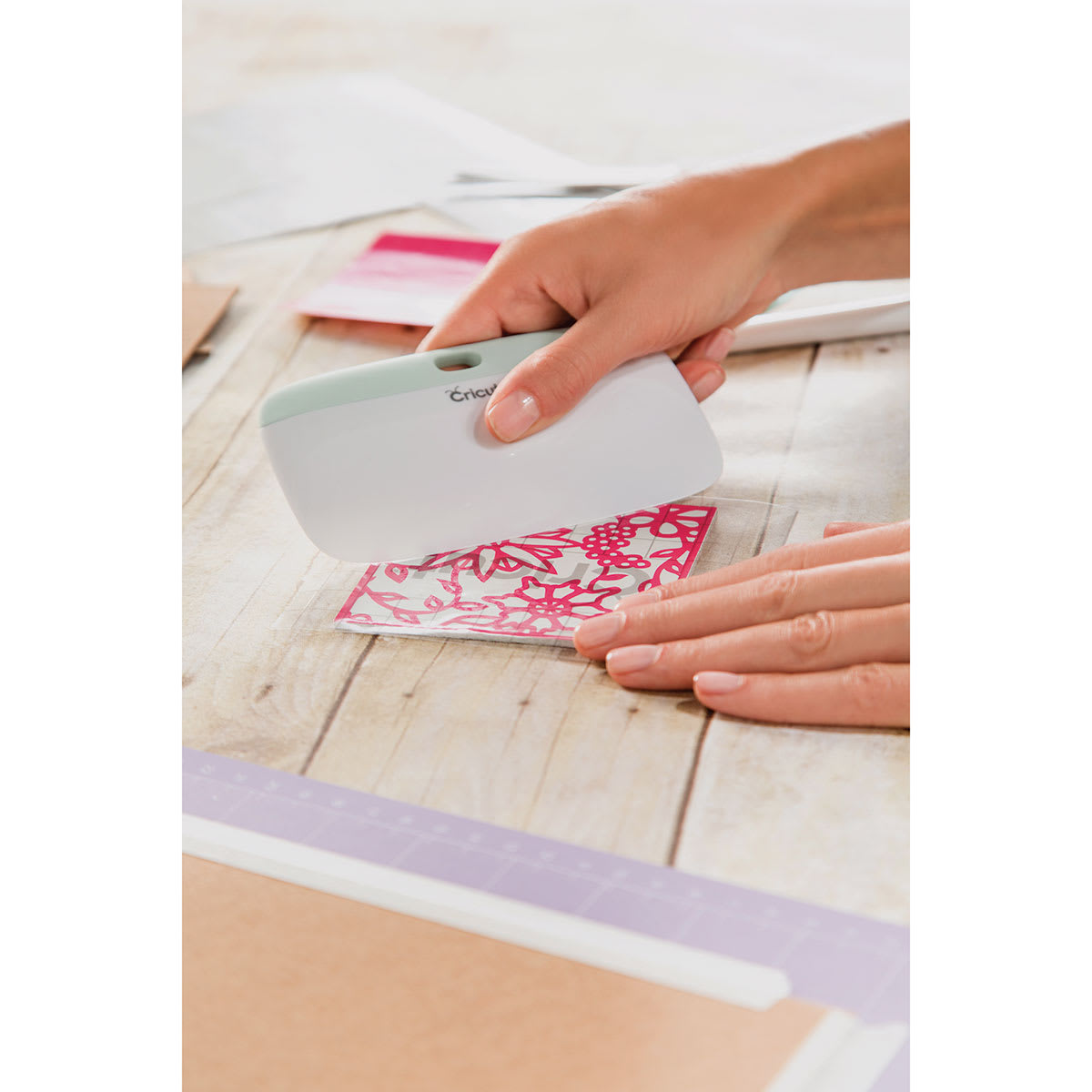 Cricut XL Scraper - Hands burnishing colored paper with scraper