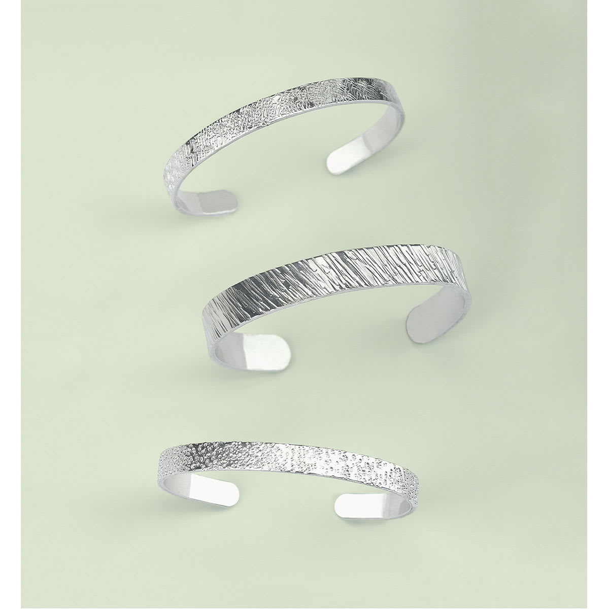 ImpressArt Texture Stamper - Three bracelets shown with various stamped effects
