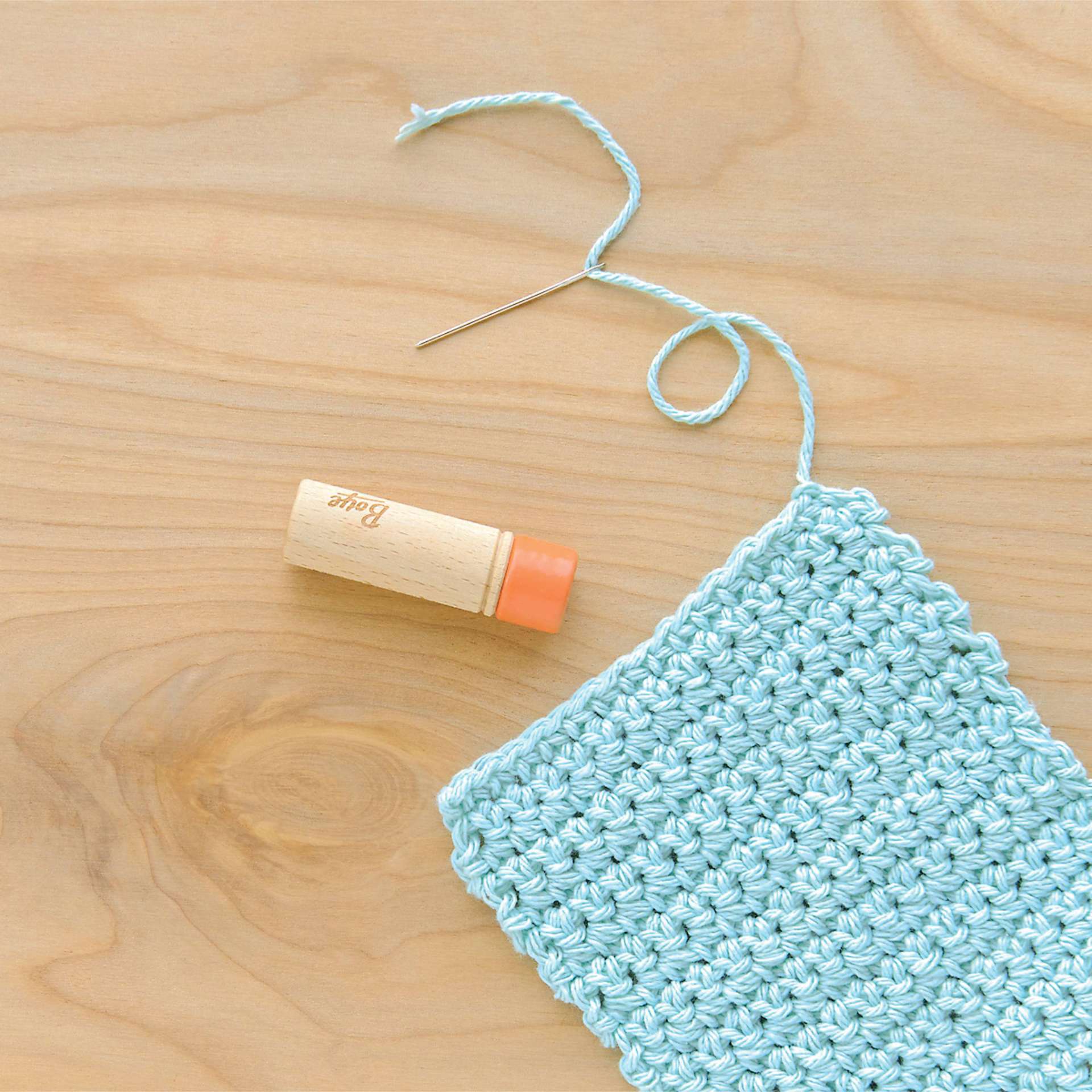 Boye Wood Container & Yarn Needles - Pkg of 6 Needles, Coral Lid - in use, next to light blue knitting example