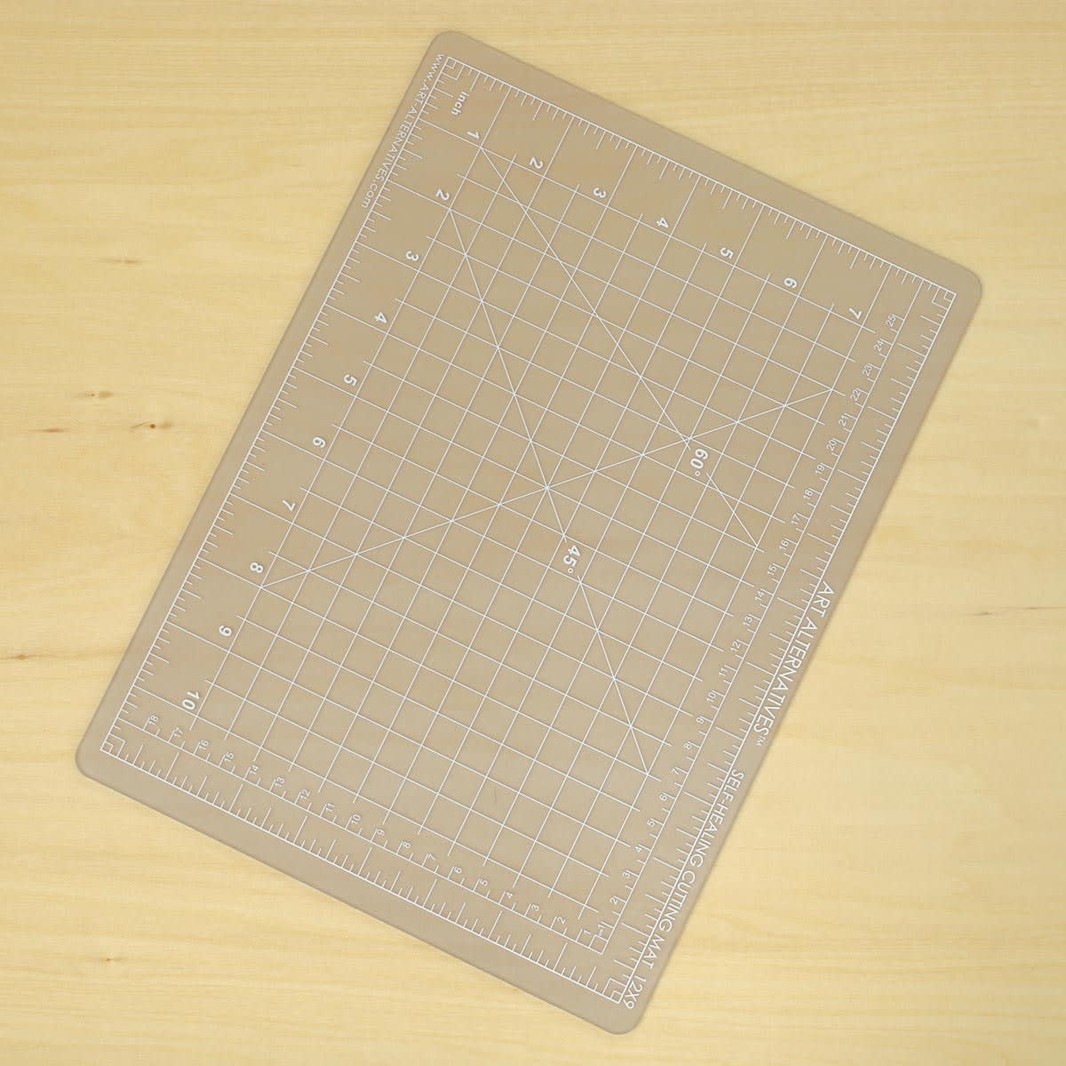 Art Alternatives Self-Healing Cutting Mat - Clear, 9" x 12" laying on table