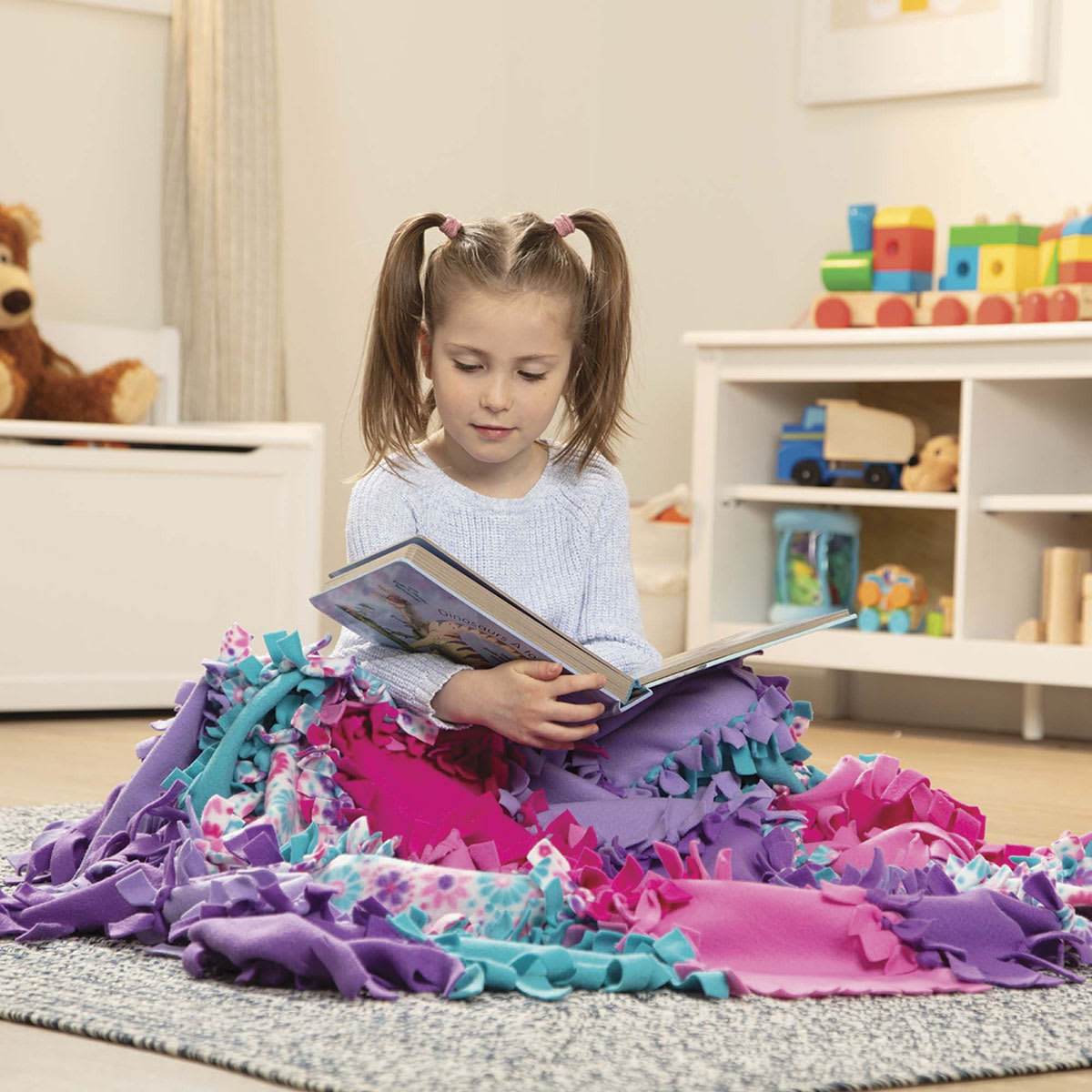 Melissa & Doug Created by Me Flower Fleece Quilt - Child reading book under finished Quilt
