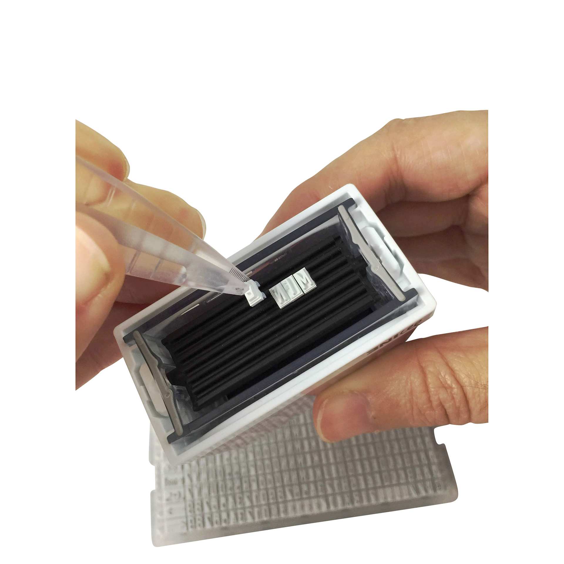 Colop Craft Labeler Textile Stamp Set applying characters to ink pad with included tweezers