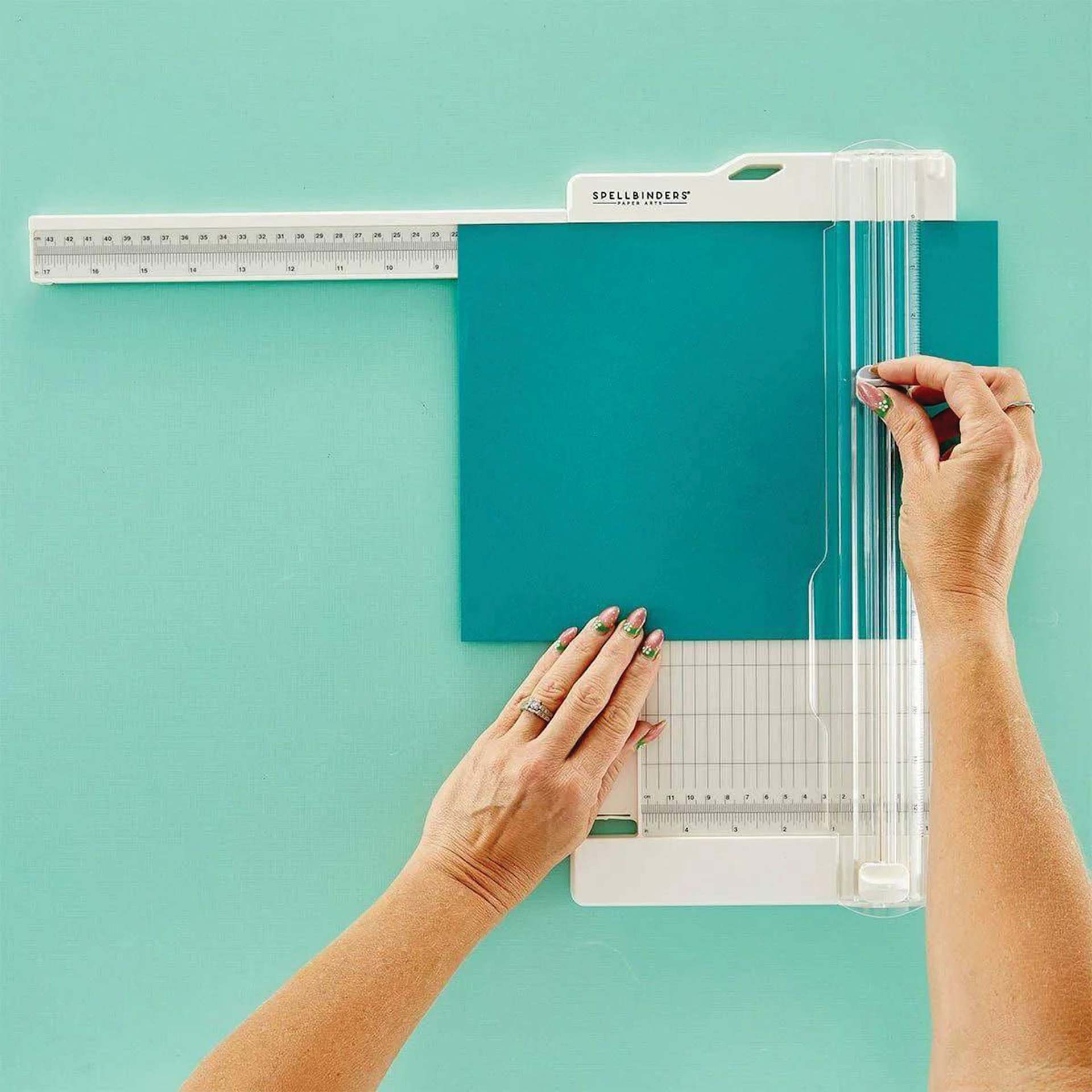 Spellbinders Paper Trimmer and Scorer with paper being held in place to cut