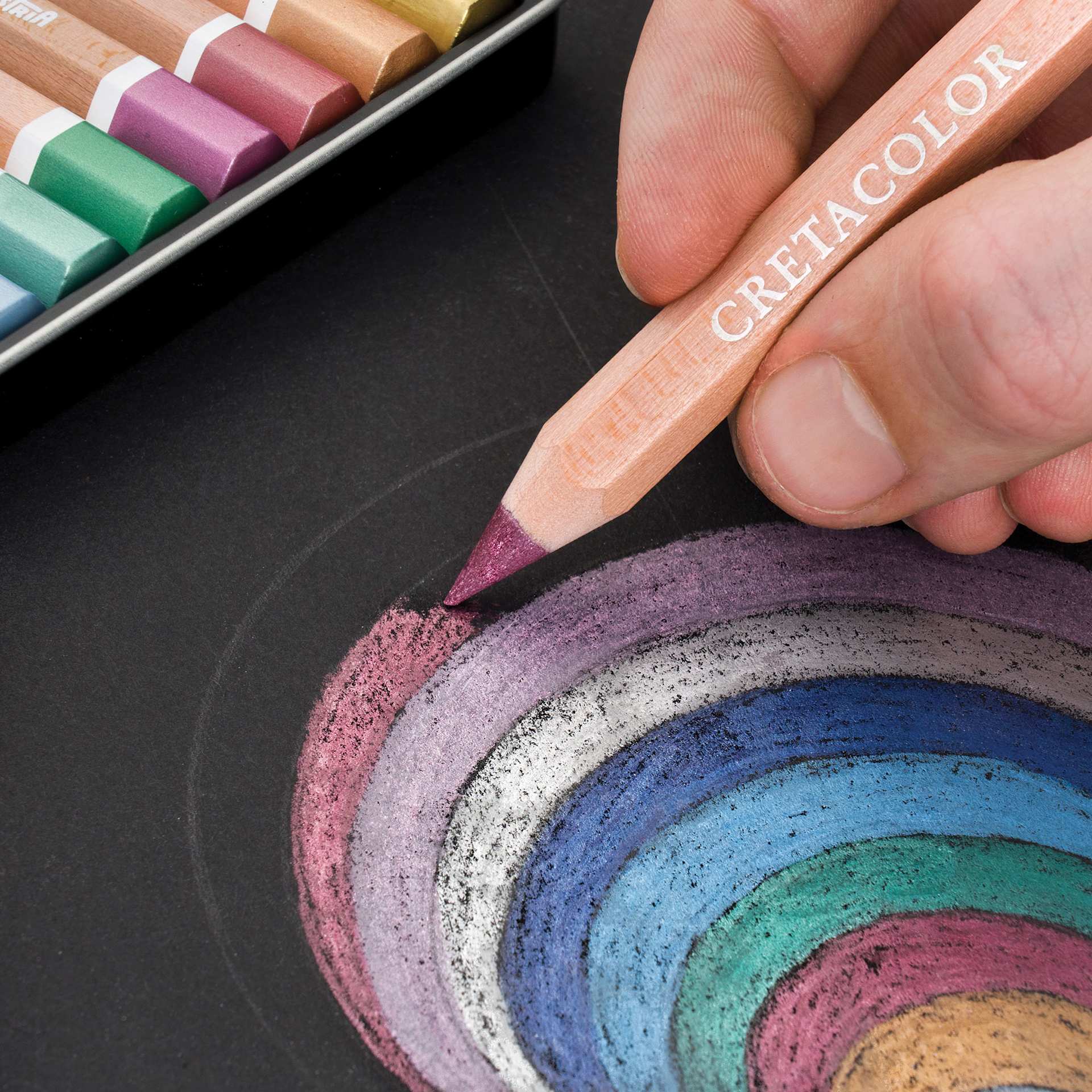 Cretacolor The Brilliants Metallic Drawing Set, close-up of a pencil in use coloring over black paper