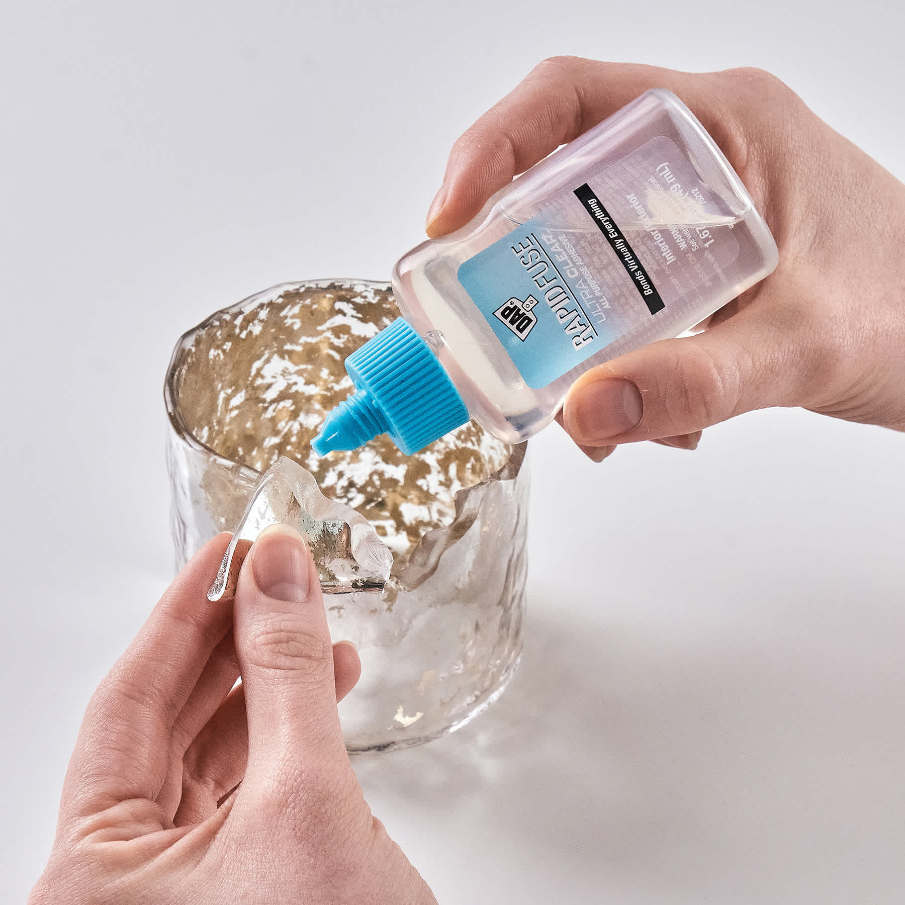 DAP RapidFuse Ultra Clear All Purpose Adhesive - 1.67 oz Bottle being applied to glass
