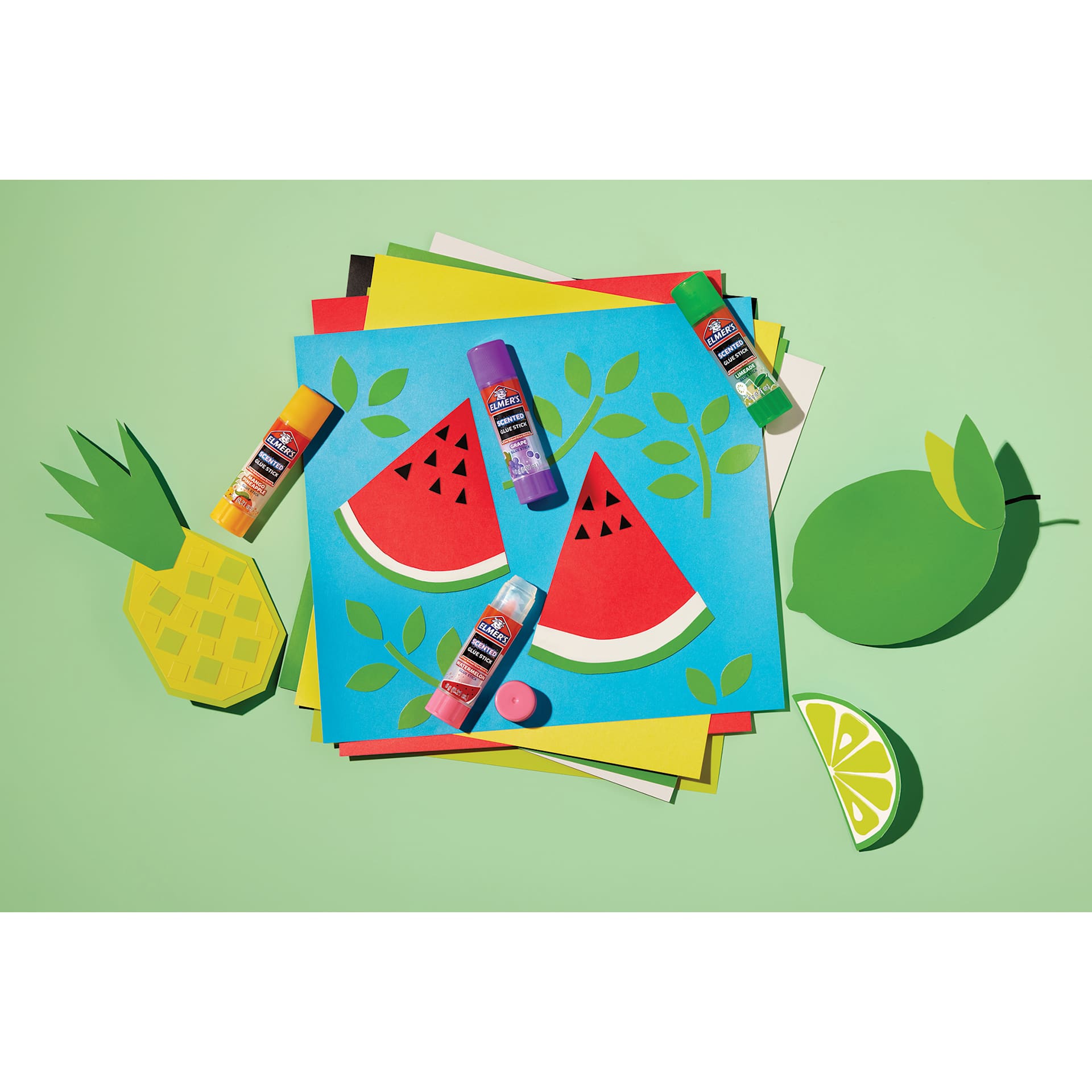 Elmer’s Scented Glue Sticks - Fruity, Pkg of 4, laid out on top of colored paper
