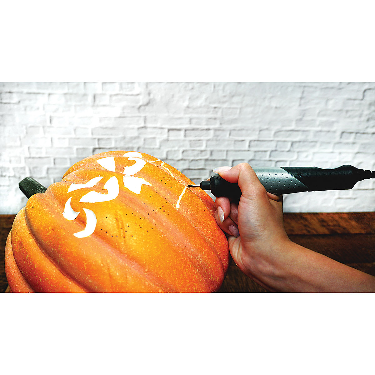 Dremel General Purpose Accessory Kit - Person using tool to carve pumpkin