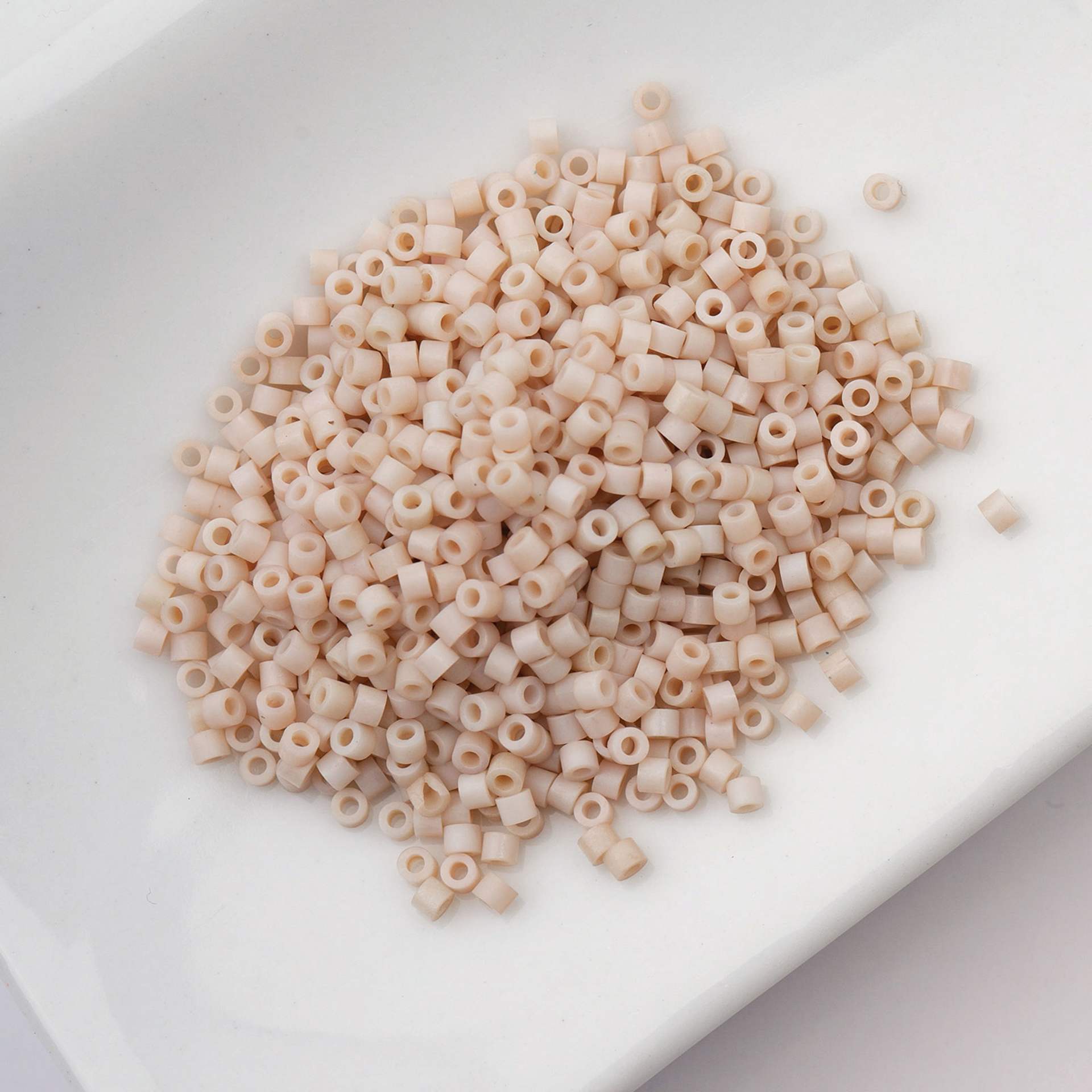 John Bead Cylin 11/0 Matte Macaron Cylindrical Seed Beads - Oat Milk sitting in dish