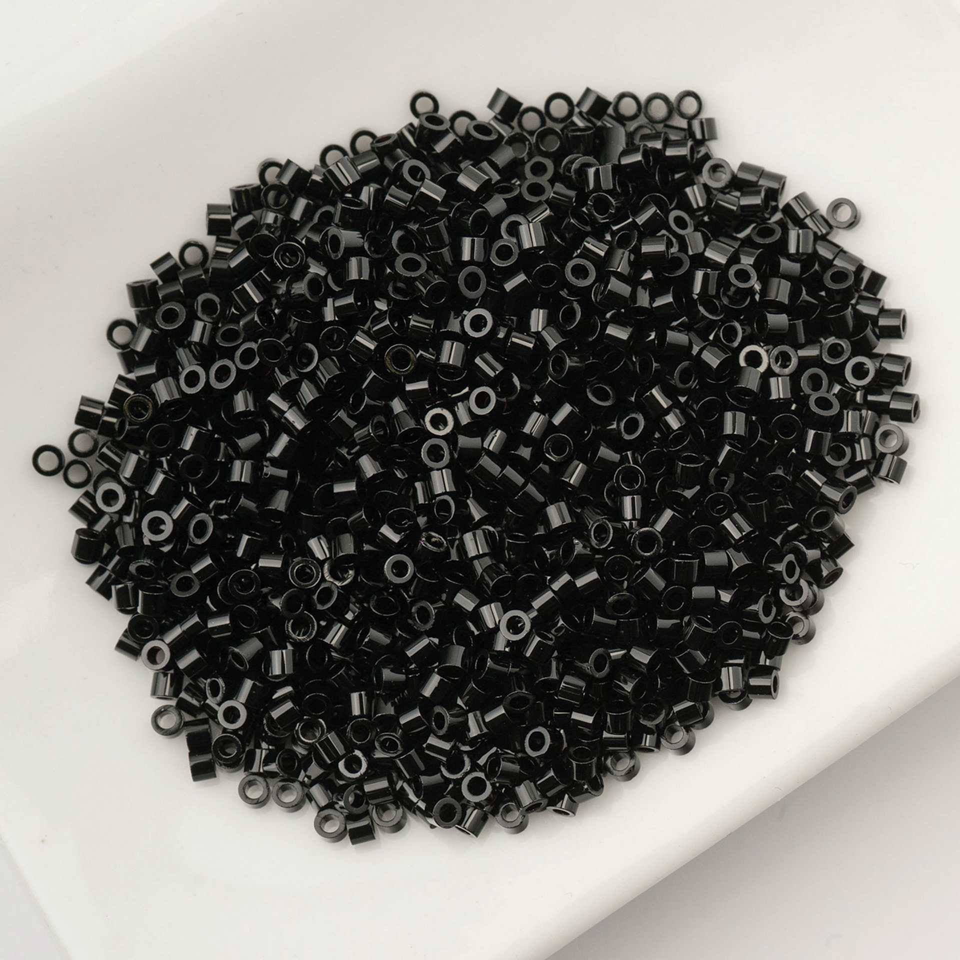 John Bead Cylin 11/0 Cylindrical Seed Beads - Black Opaque sitting in dish
