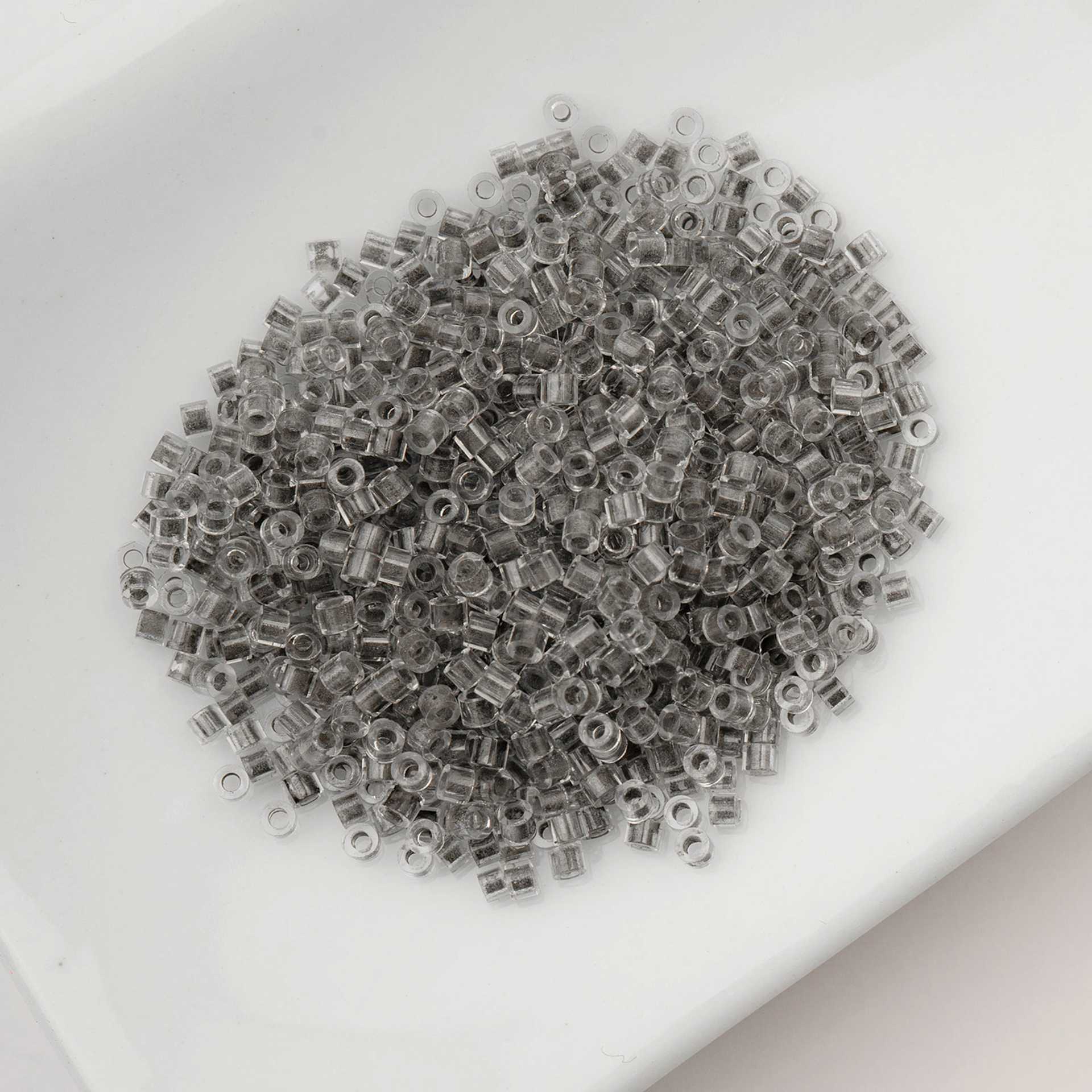 John Bead Cylin 11/0 Glow in the Dark Cylindrical Seed Beads - Grey, 25g sitting in dish