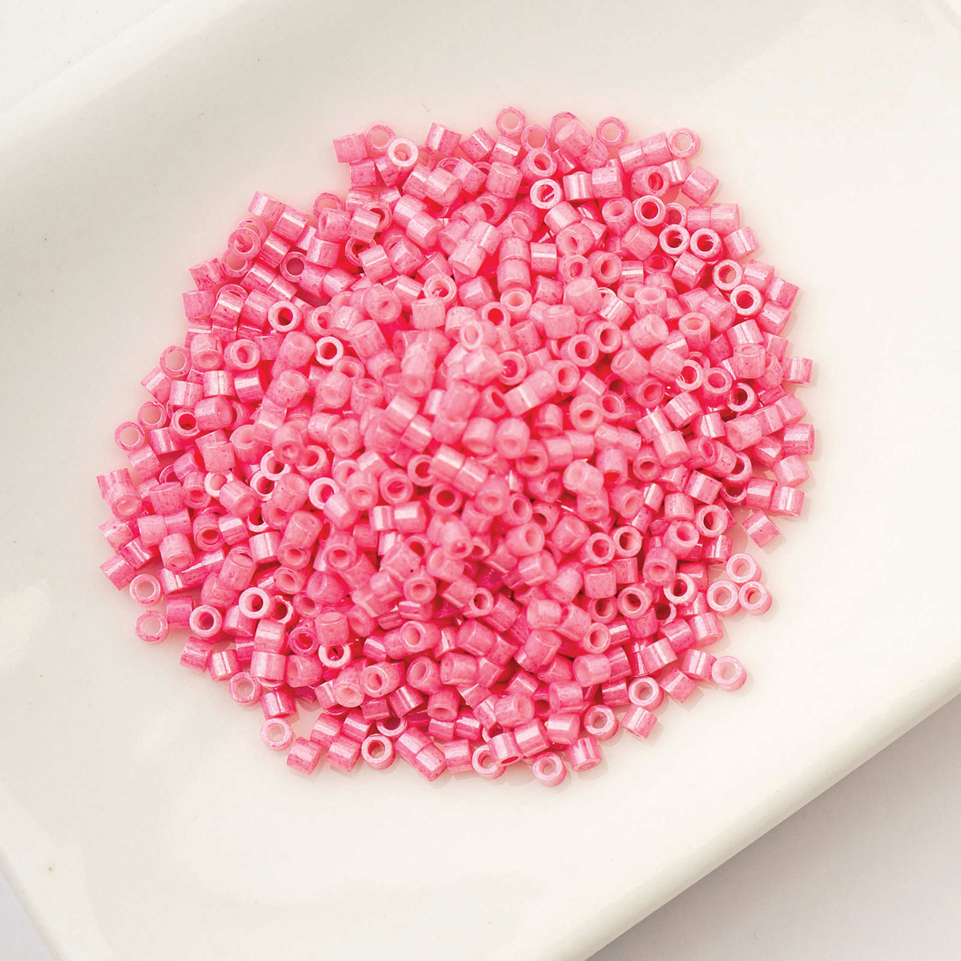 John Bead Cylin 11/0 Cylindrical Seed Beads - Pink Carnation Opaque sitting in dish